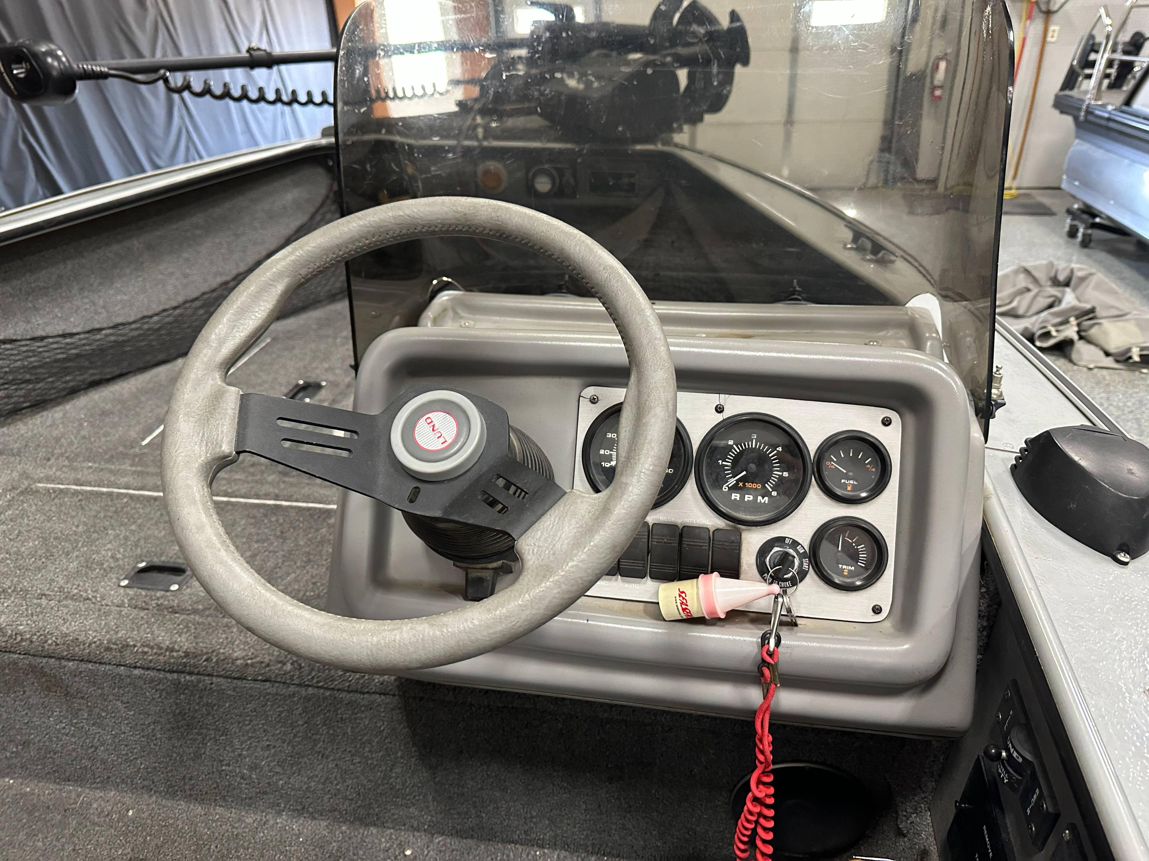 1995 Lund 1650 DLX boat dashboard with steering wheel and instrument panel.