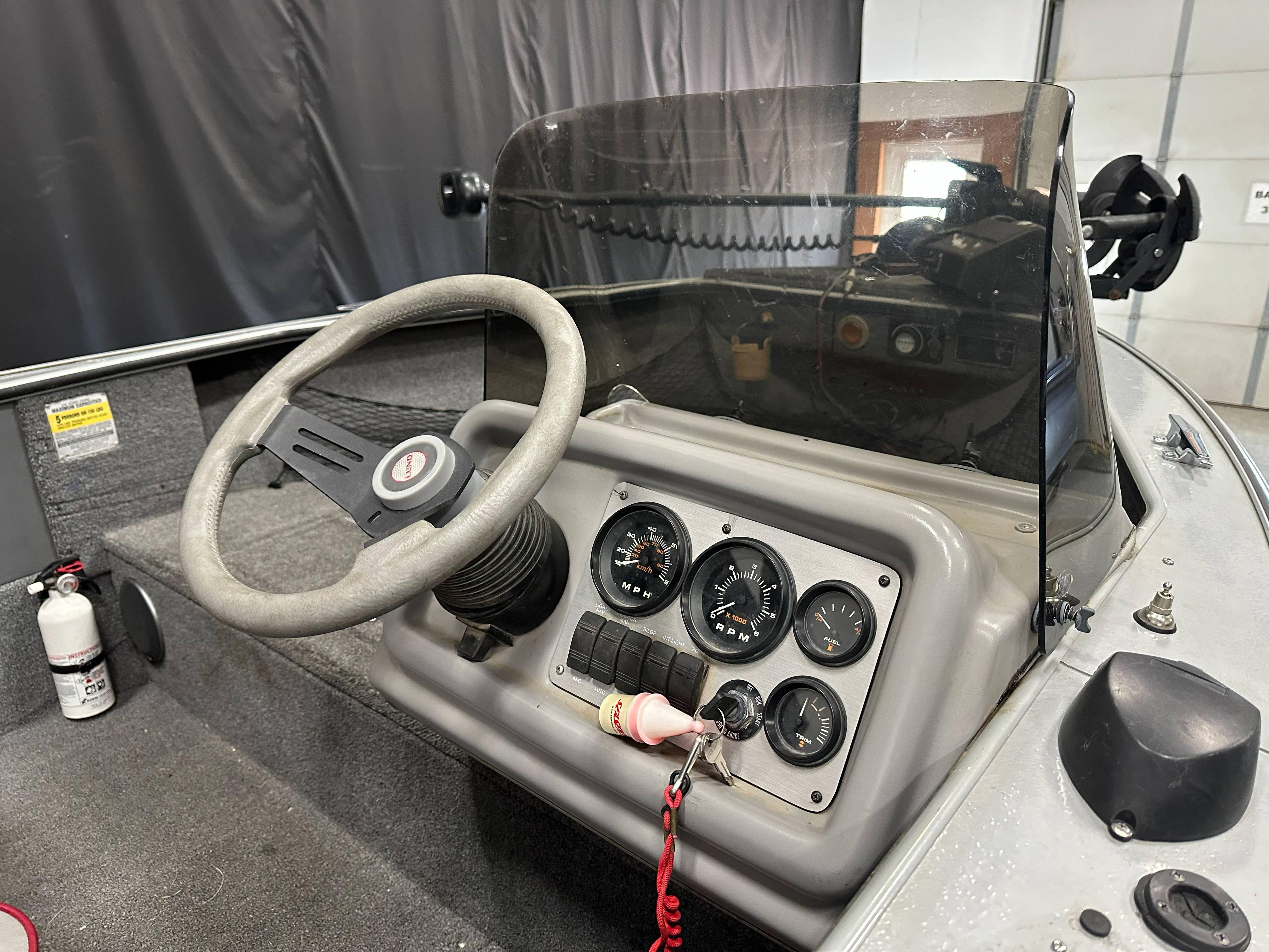 1995 Lund 1650 DLX boat dashboard with steering wheel and gauges.