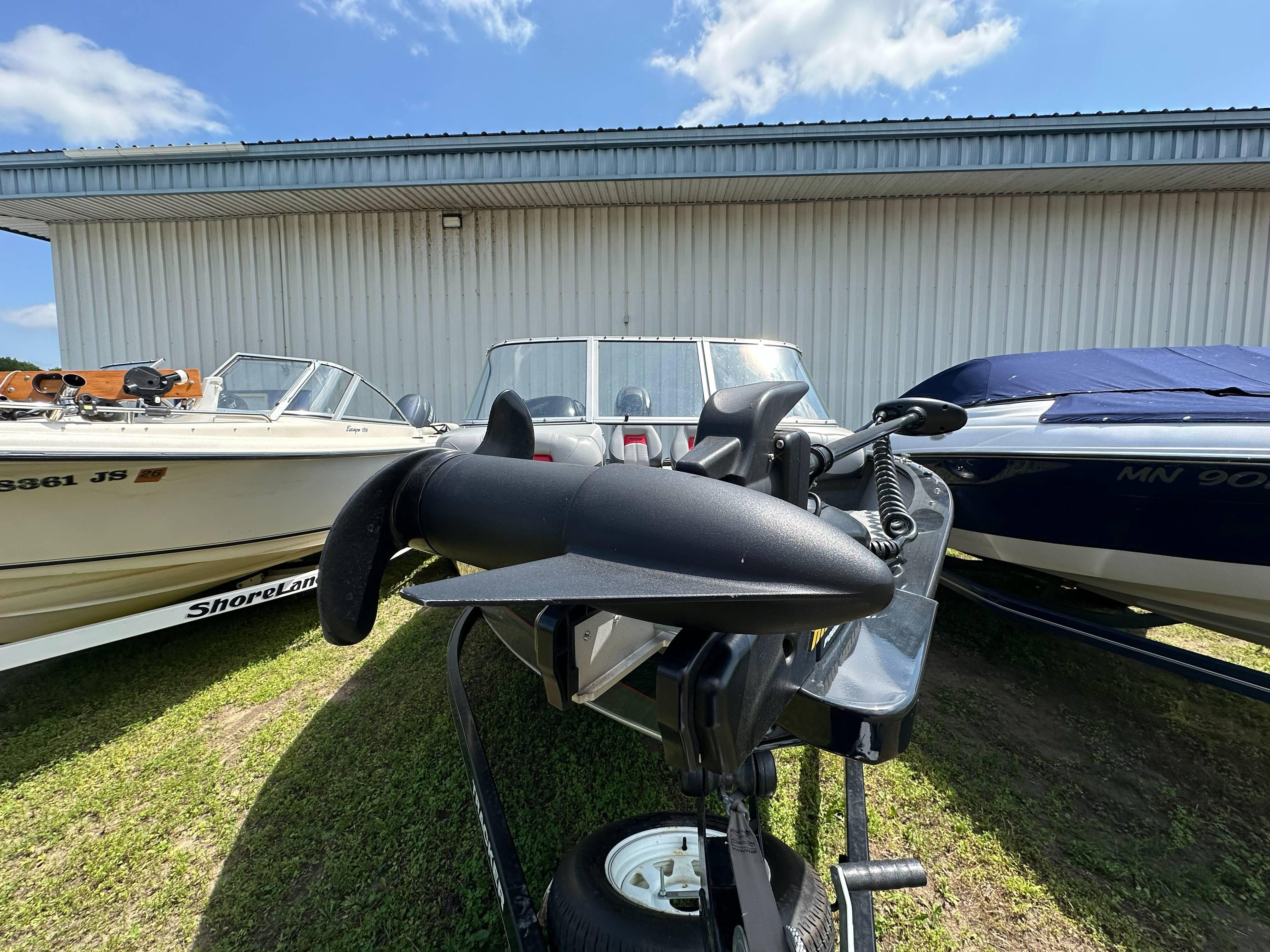 2013 Tracker Pro Guide V-175 WT boat parked outdoors, surrounded by other boats.