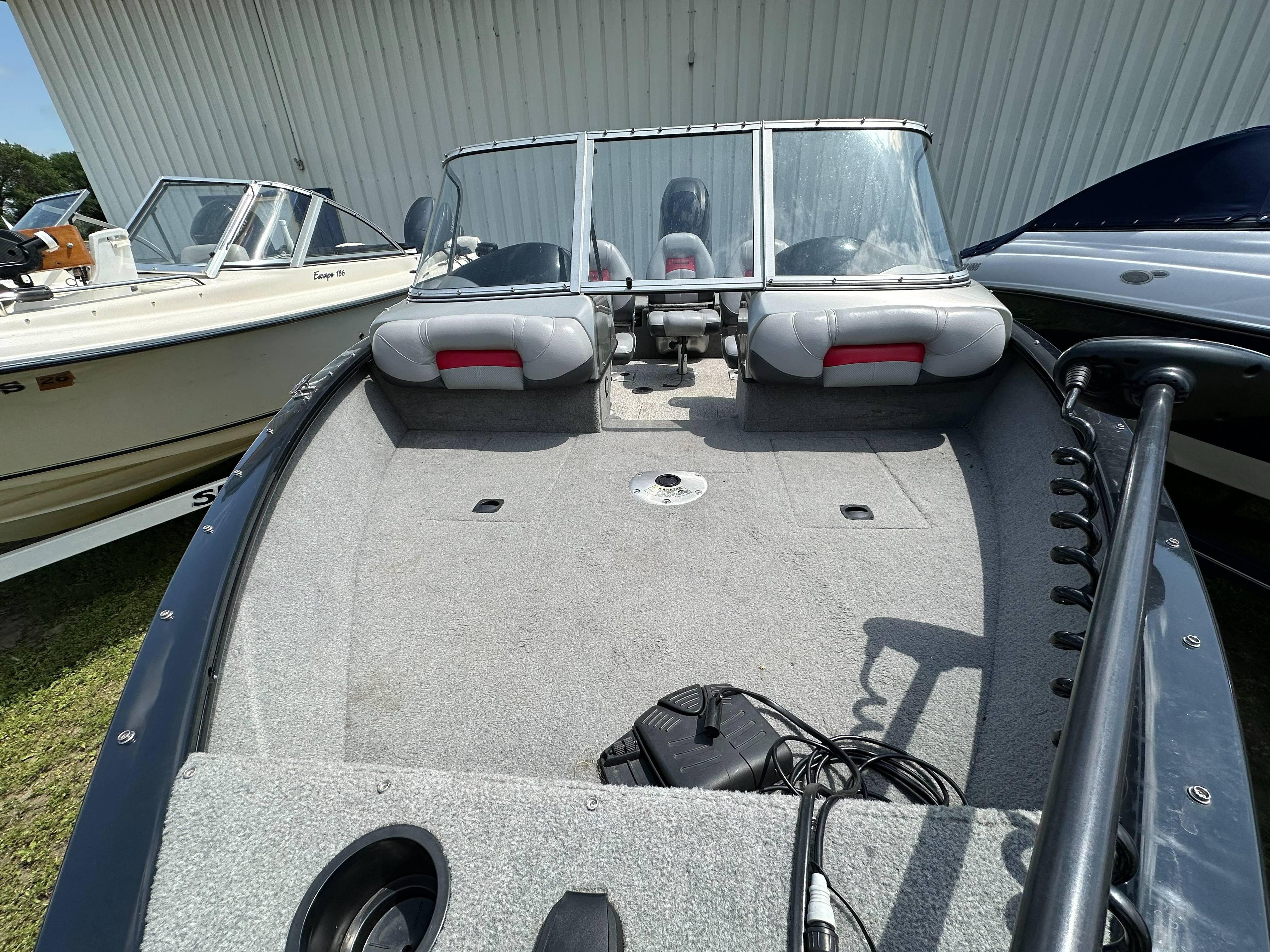 2013 Tracker Pro Guide V-175 WT boat with spacious deck and windshield, parked outdoors.