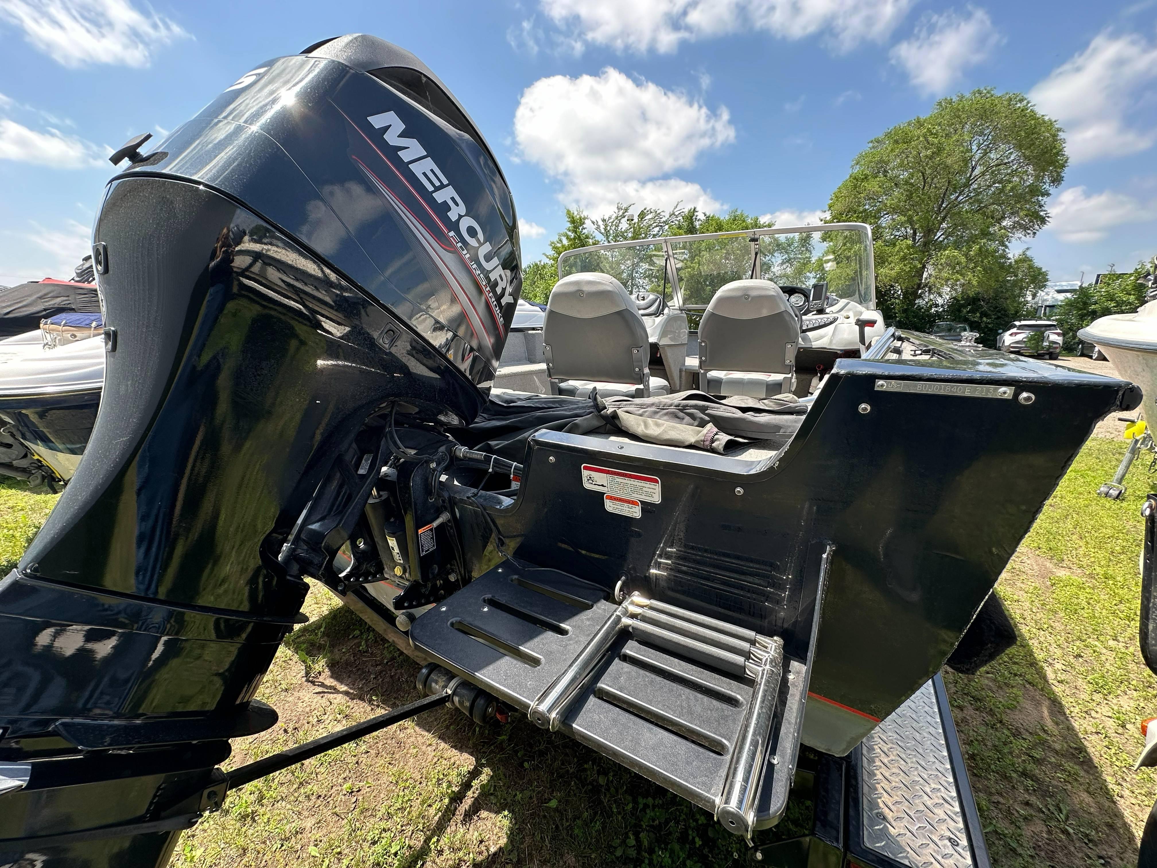 2013 Tracker Pro Guide V-175 WT boat with Mercury outboard motor on grassy area.