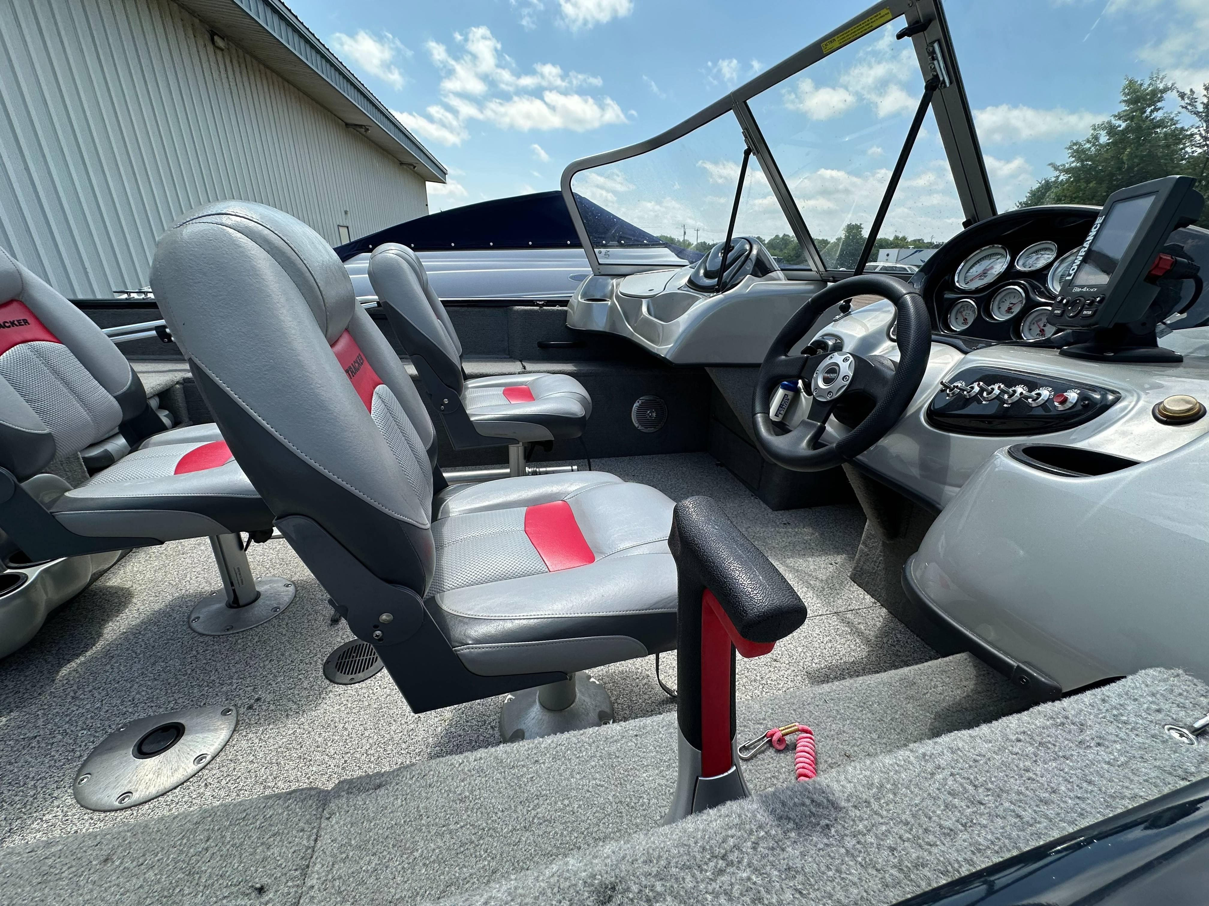 2013 Tracker Pro Guide V-175 WT boat interior with gray and red seating, steering console, and gauges.
