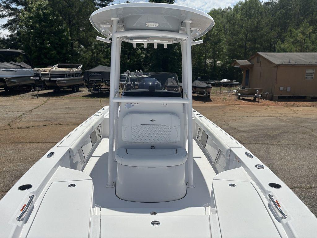 2024 Sportsman Masters 227 Bay boat, white interior, outdoor setting, surrounded by trees and other boats.