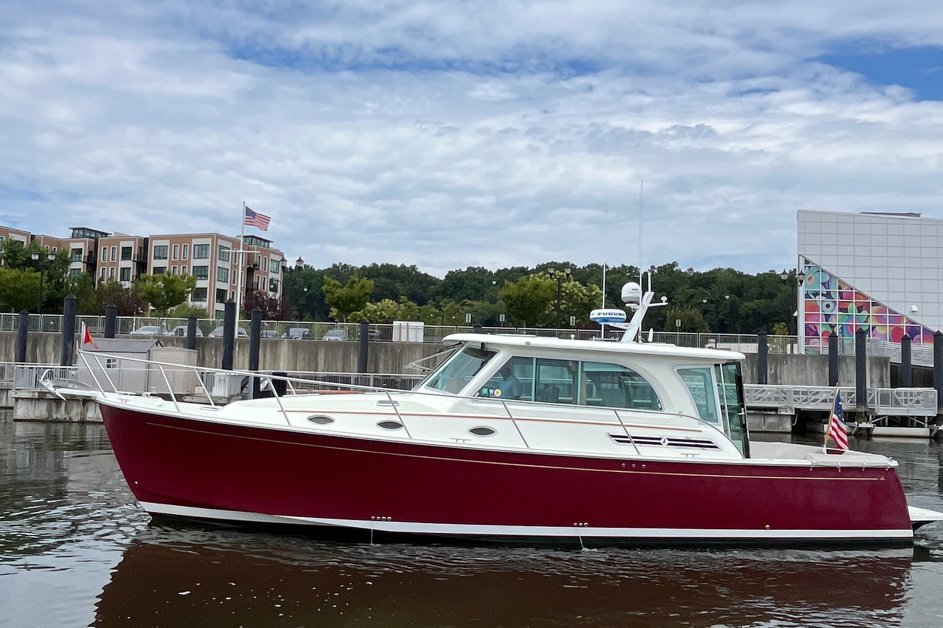 2017 Back Cove 41 boat with red hull docked in a marina.