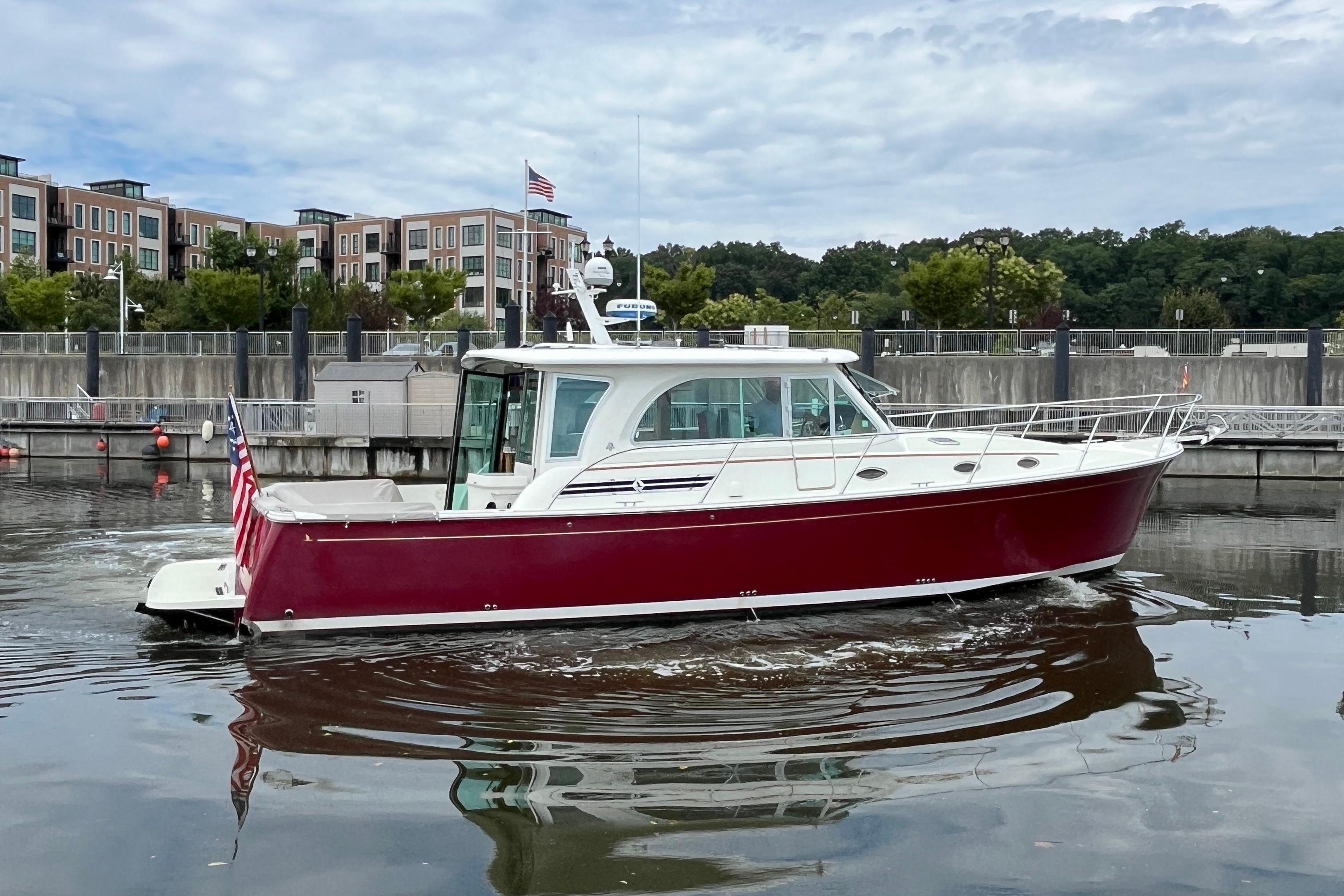 2017 Back Cove 41 boat with red hull docked in a marina.