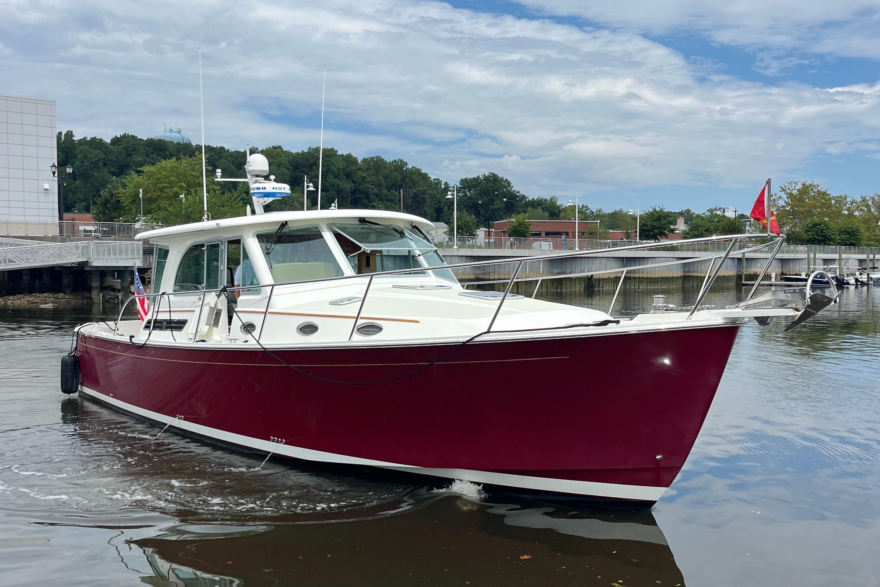 2017 Back Cove 41 boat with red hull docked in a marina.
