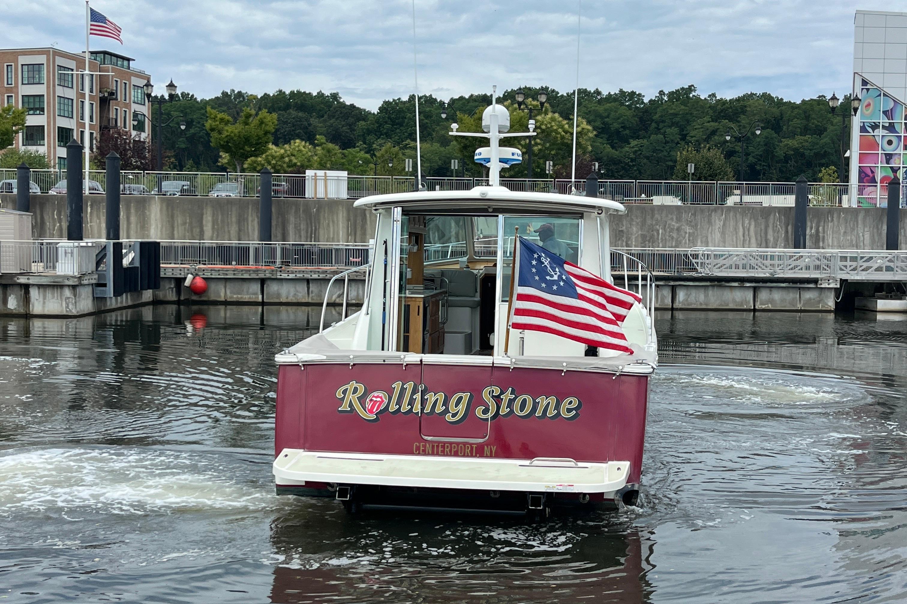 2017 Back Cove 41 boat named u0022Rolling Stoneu0022 with American flag, docked in a marina.