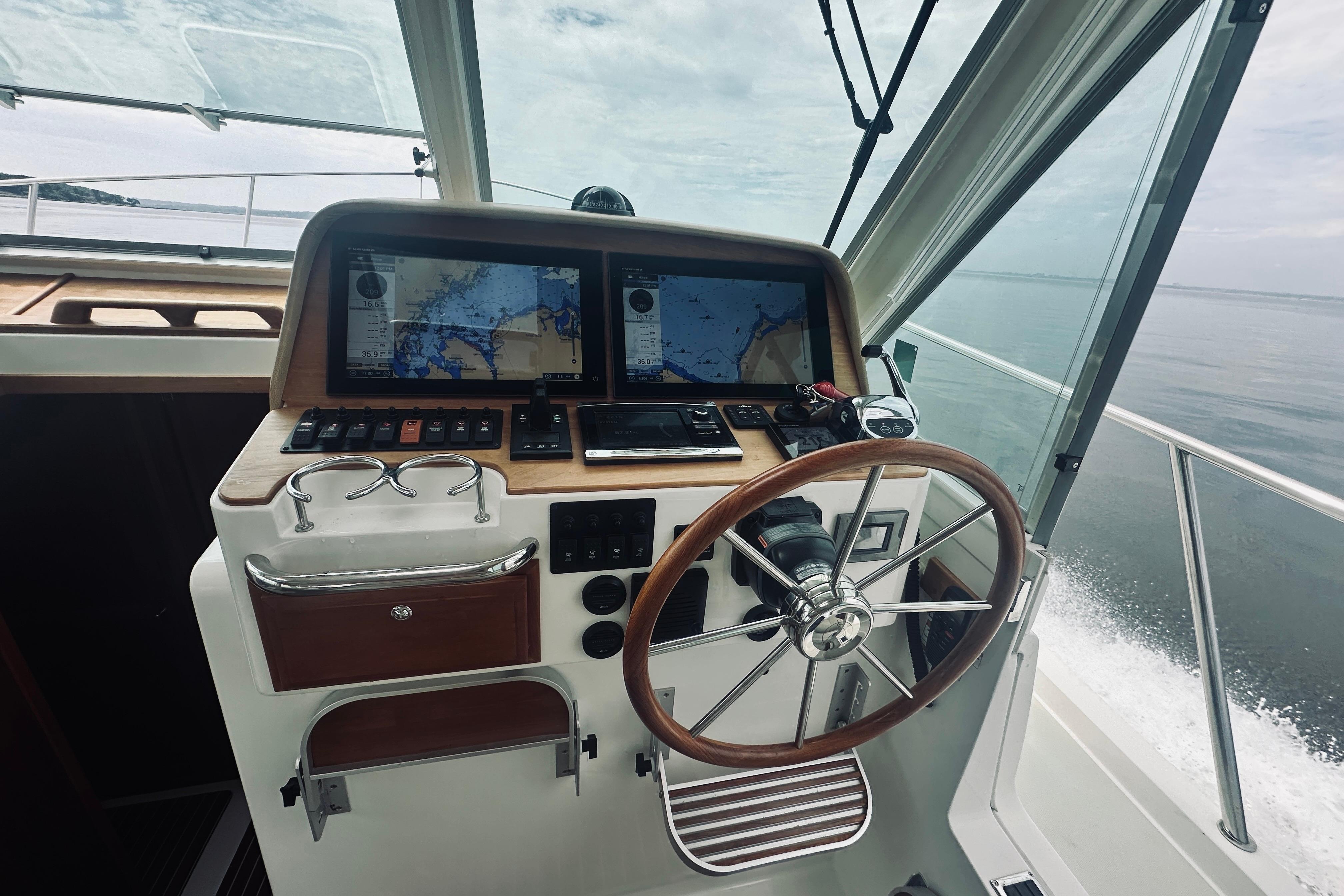 Helm of 2017 Back Cove 41 boat with navigation screens and steering wheel.