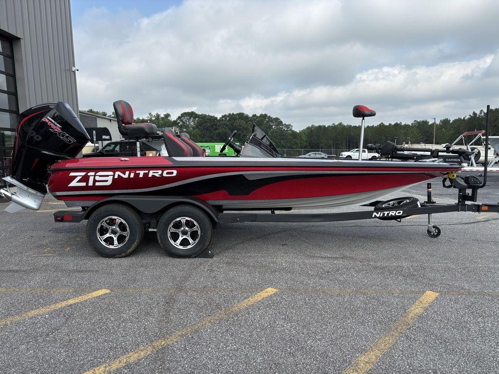 2025 Nitro Z19 Pro boat on trailer, red and black design, parked outdoors.