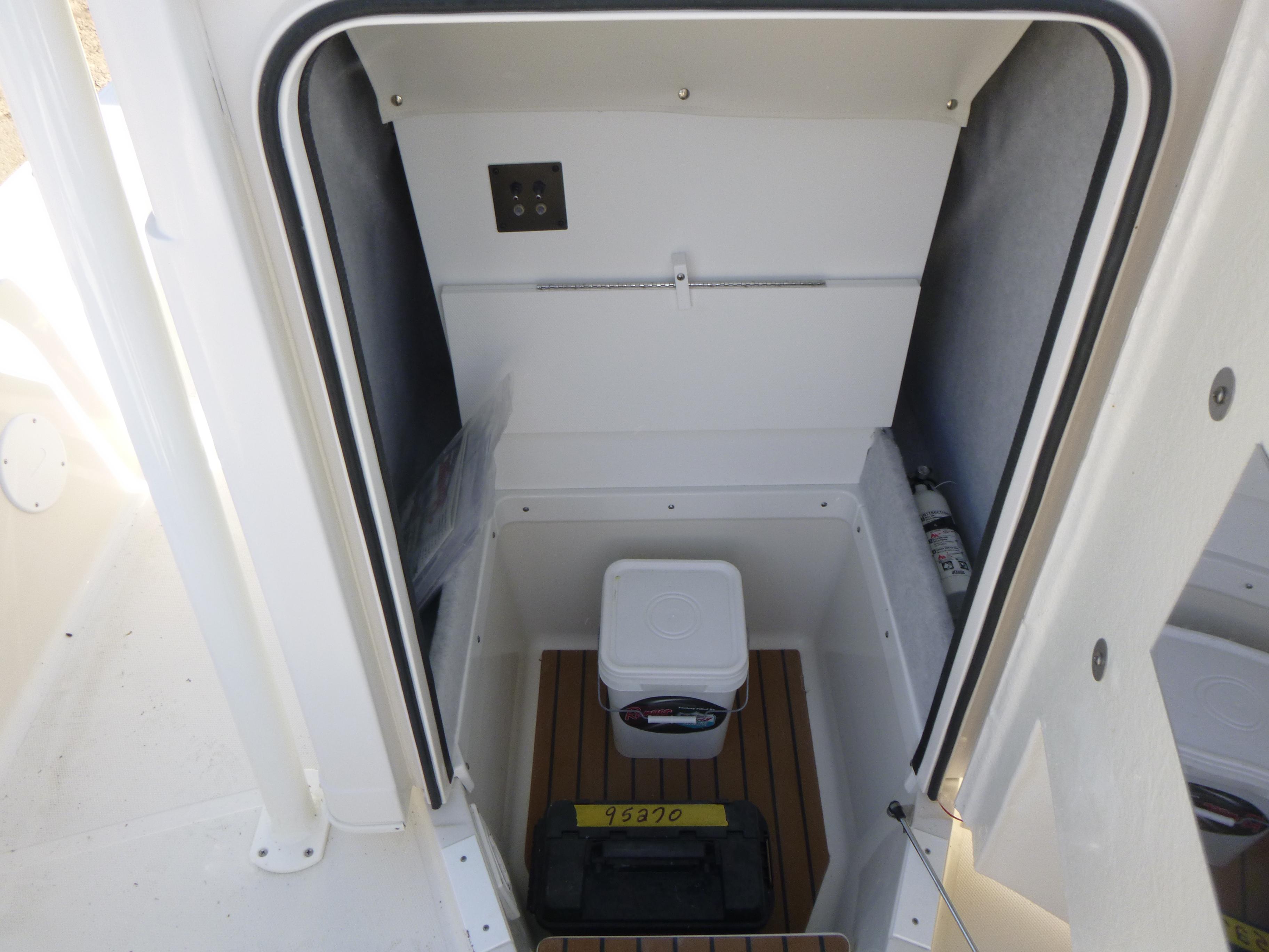 2024 Ranger 2360 Bay Ranger storage compartment with cooler and fire extinguisher.