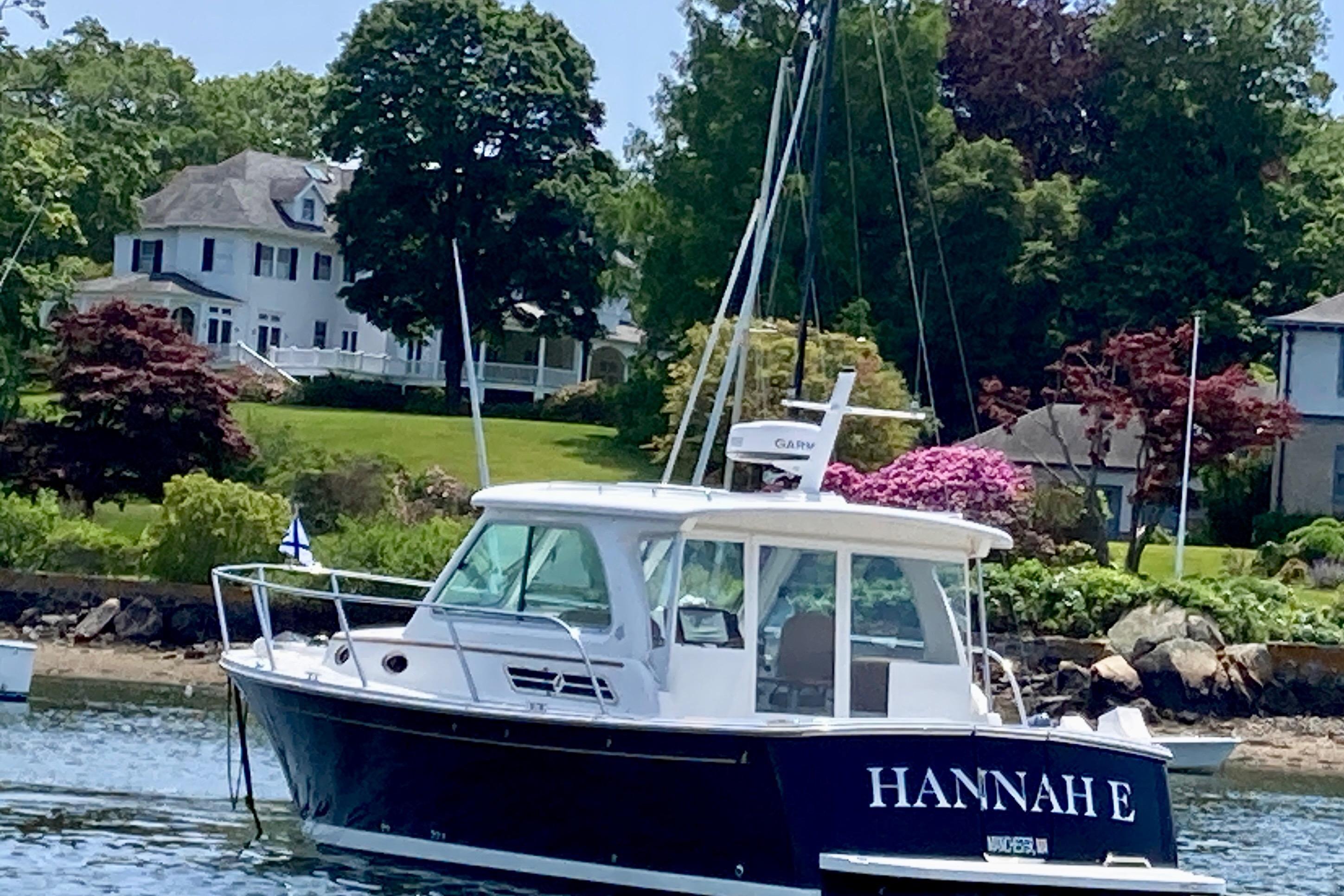 2018 Back Cove 30 boat named u0022Hannah Eu0022 on water near a scenic shoreline.