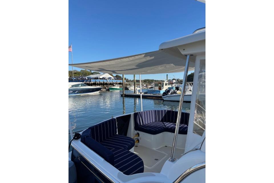 2018 Back Cove 30 boat with striped seating, docked in a sunny marina.