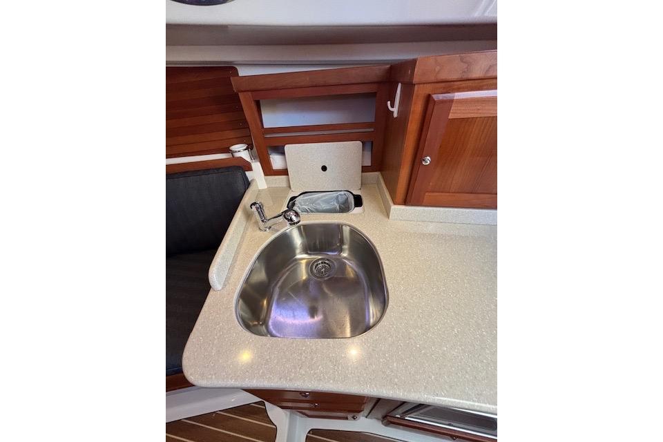 2018 Back Cove 30 yacht interior with stainless steel sink and wooden cabinetry.