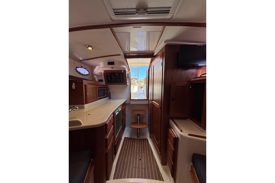 Interior of 2018 Back Cove 30 yacht, featuring wood cabinetry and modern amenities.