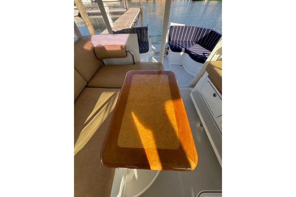 Interior of 2018 Back Cove 30 boat with wooden table and cushioned seating.