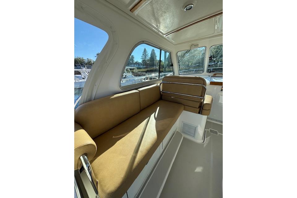Interior of 2018 Back Cove 30 boat with tan seating and large windows.