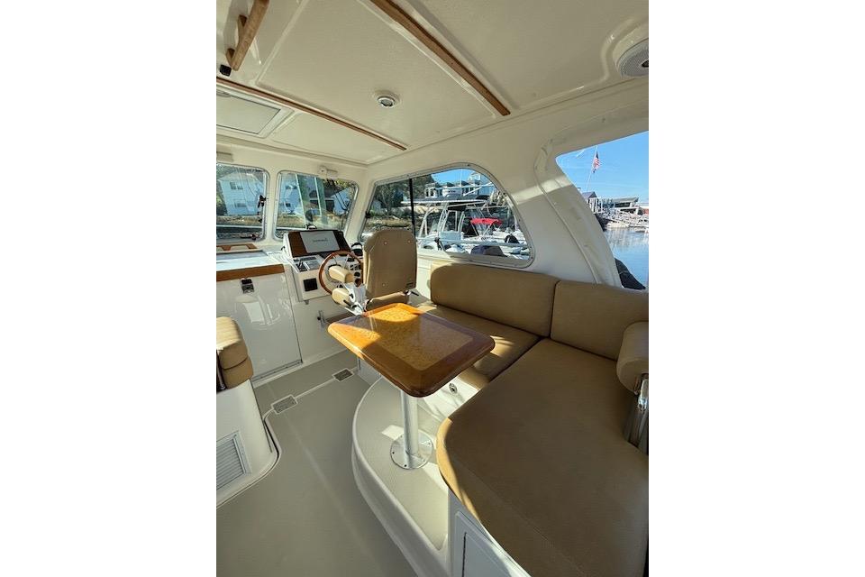 Interior of a 2018 Back Cove 30 boat with beige seating and wooden table.