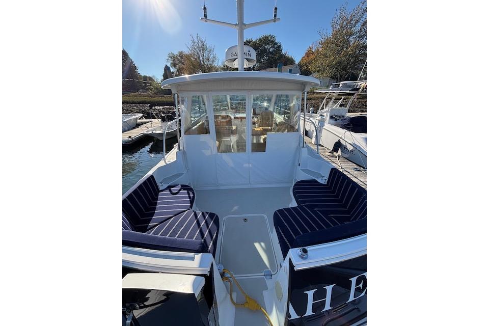 2018 Back Cove 30 boat with striped seating, docked under sunny skies.