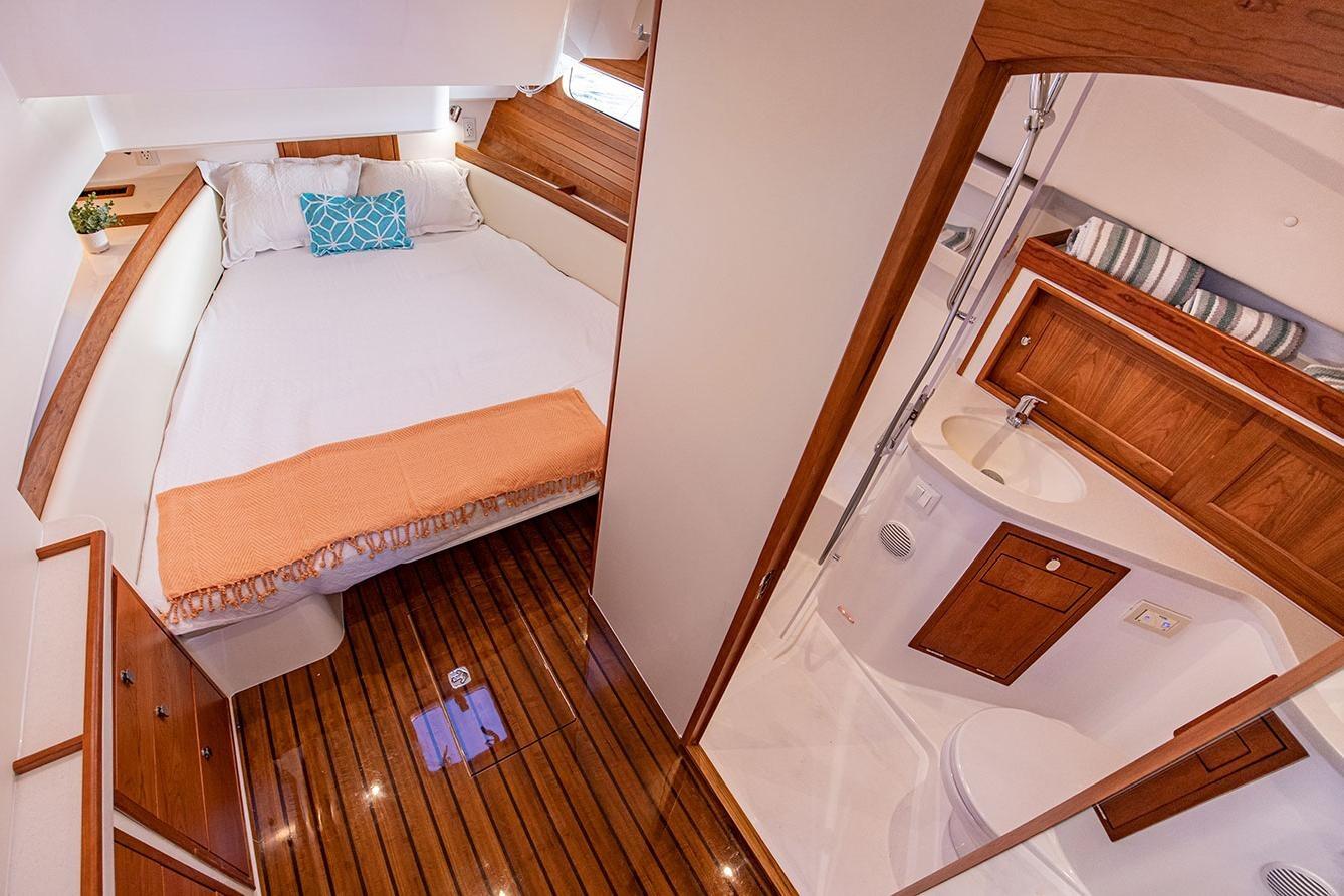 Luxurious cabin interior of 2025 MJM 4 yacht with cozy bed and modern bathroom.