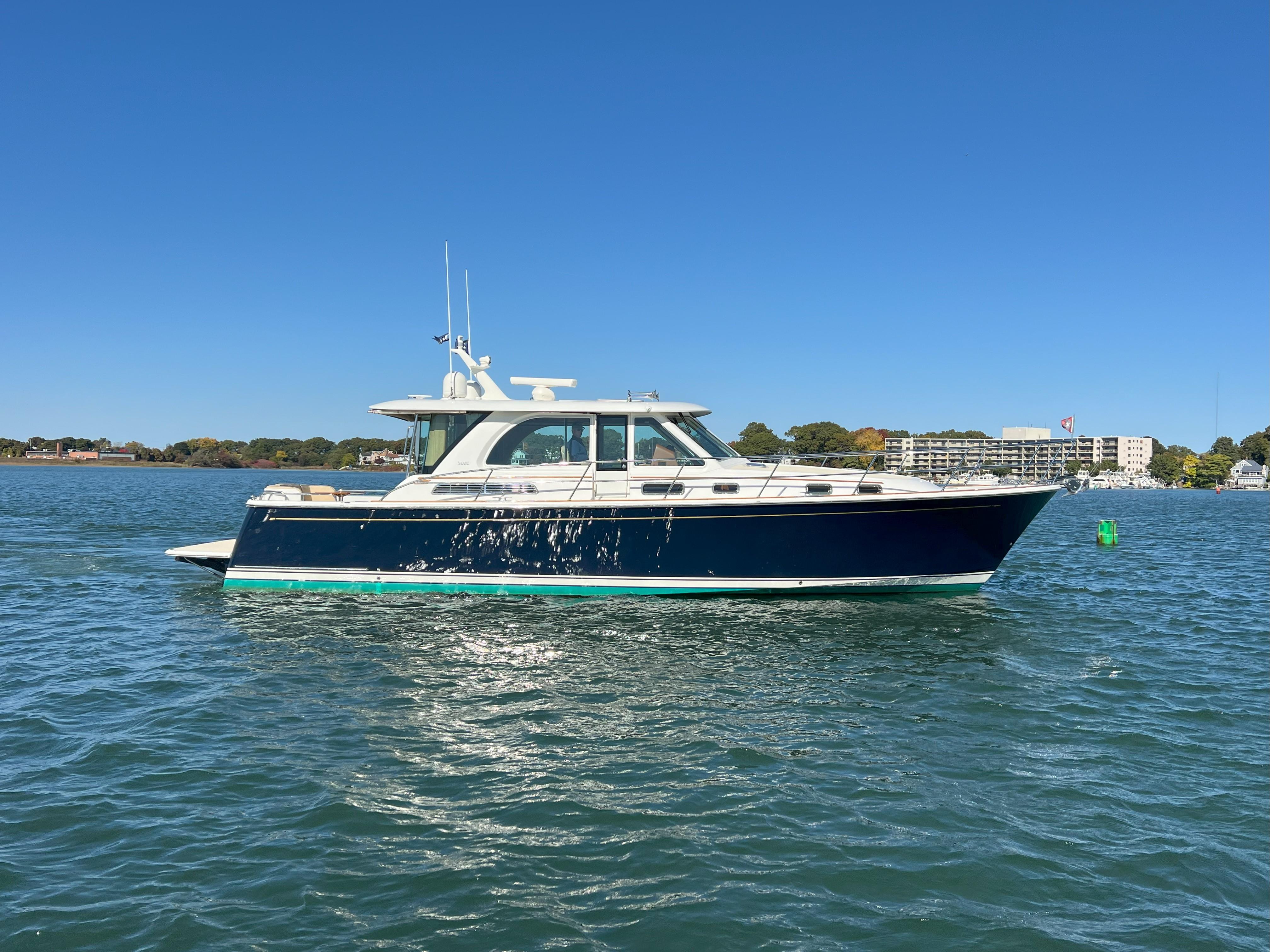2018 Sabre 45 Salon Express yacht on calm water under clear blue sky.