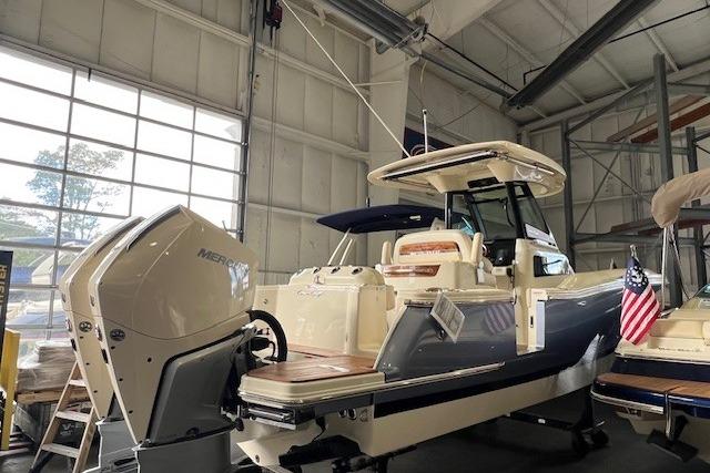 2024 Chris-Craft Catalina 28 boat in a showroom with Mercury outboard engine.