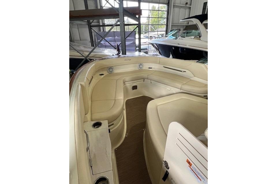 2024 Chris-Craft Catalina 28 boat interior with beige seating in a showroom.