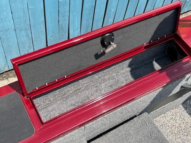Open storage compartment on 2015 Tracker Targa V-18 Combo boat, red exterior, blue background.