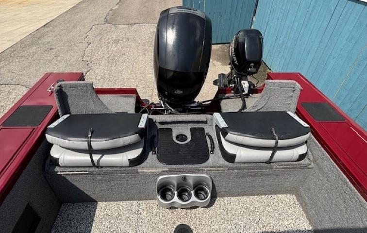 2015 Tracker Targa V-18 Combo boat interior with dual seats and motor, docked near blue wall.