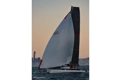 2005 Marstrom Seacart 30 sailing at sunset with city skyline in background.