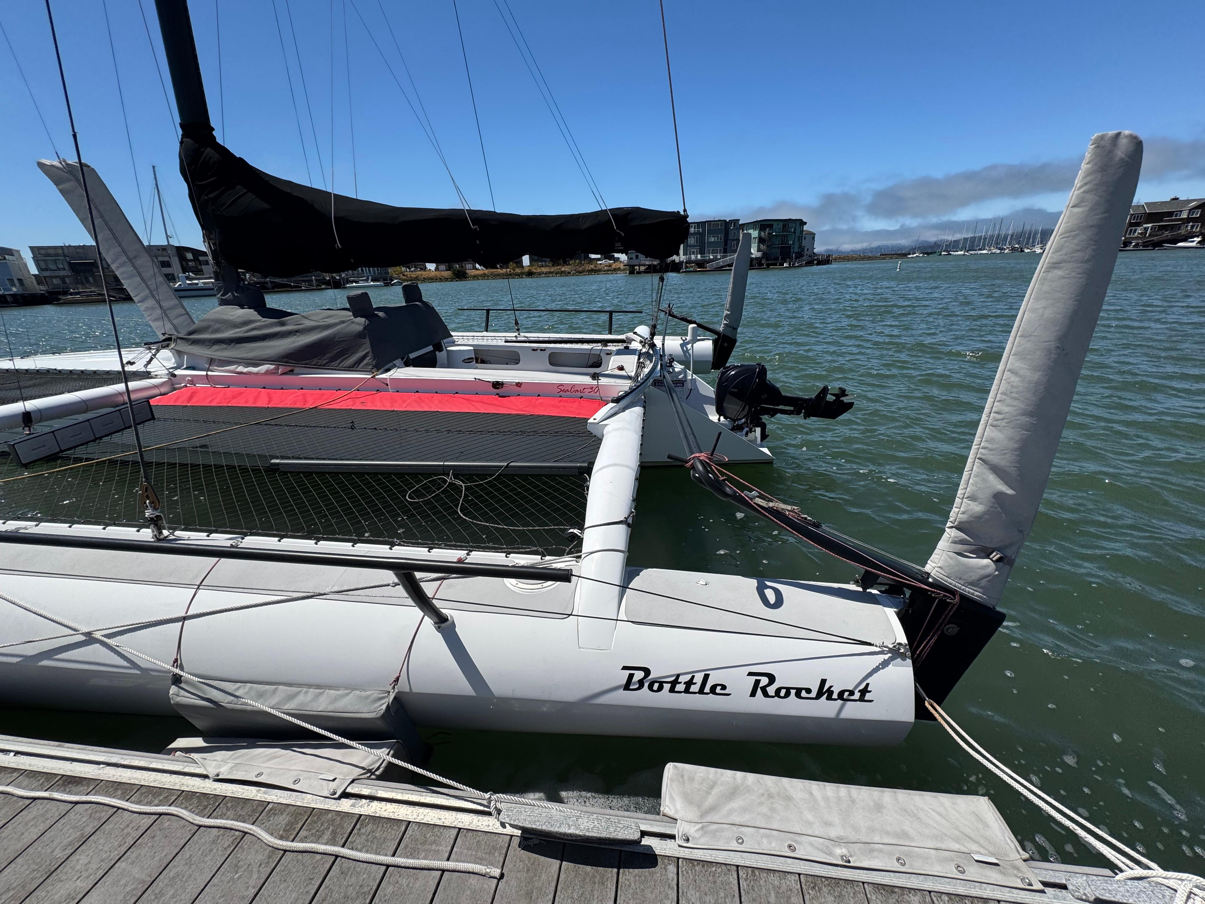 2015 Marstrom Seacart 30 trimaran named "Bottle Rocket" docked at a marina.