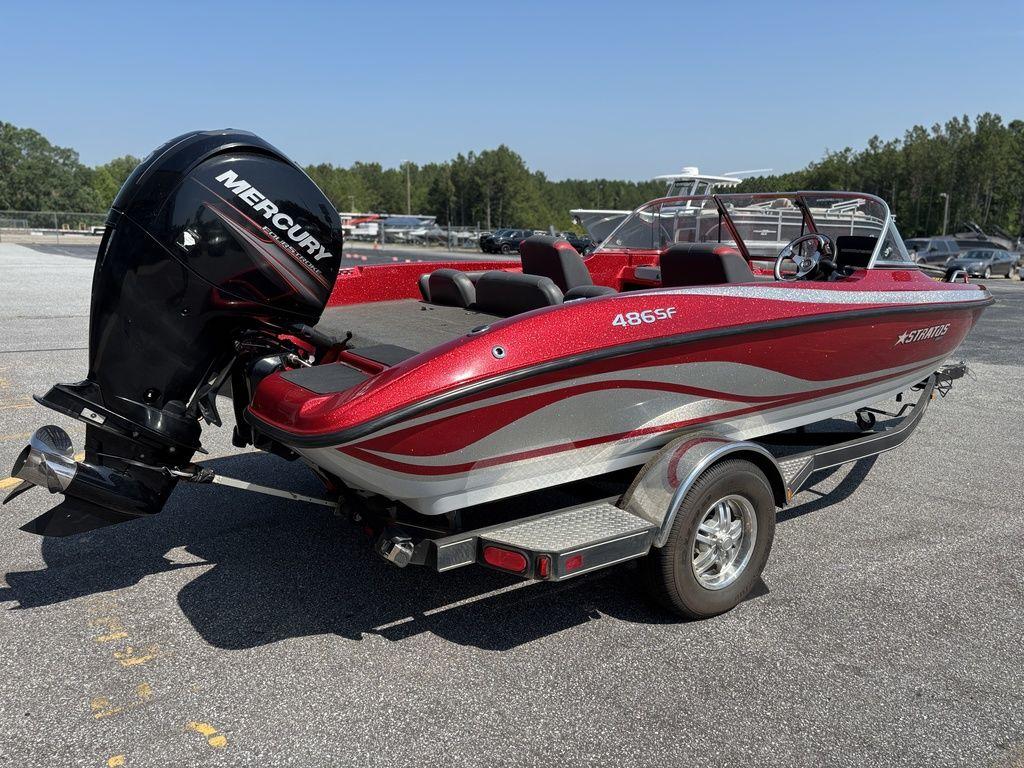 2013 Stratos 486 SF boat with Mercury engine on trailer, parked outdoors.