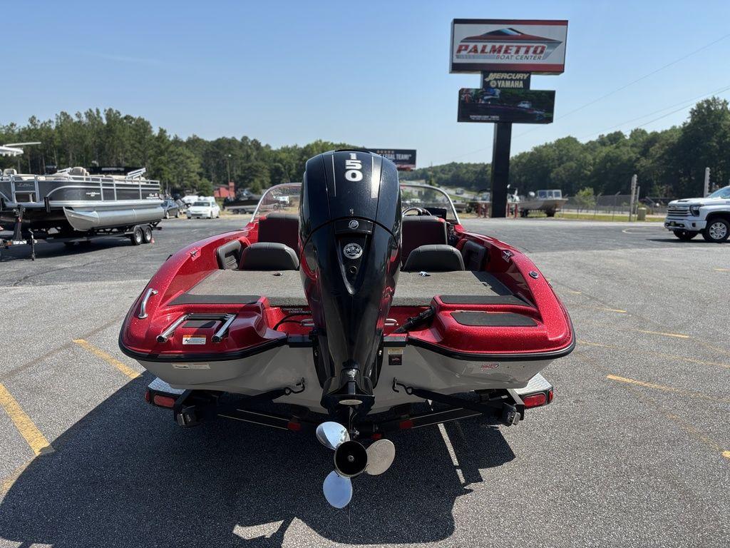 Red 2013 Stratos 486 SF boat with outboard motor at dealership parking lot.