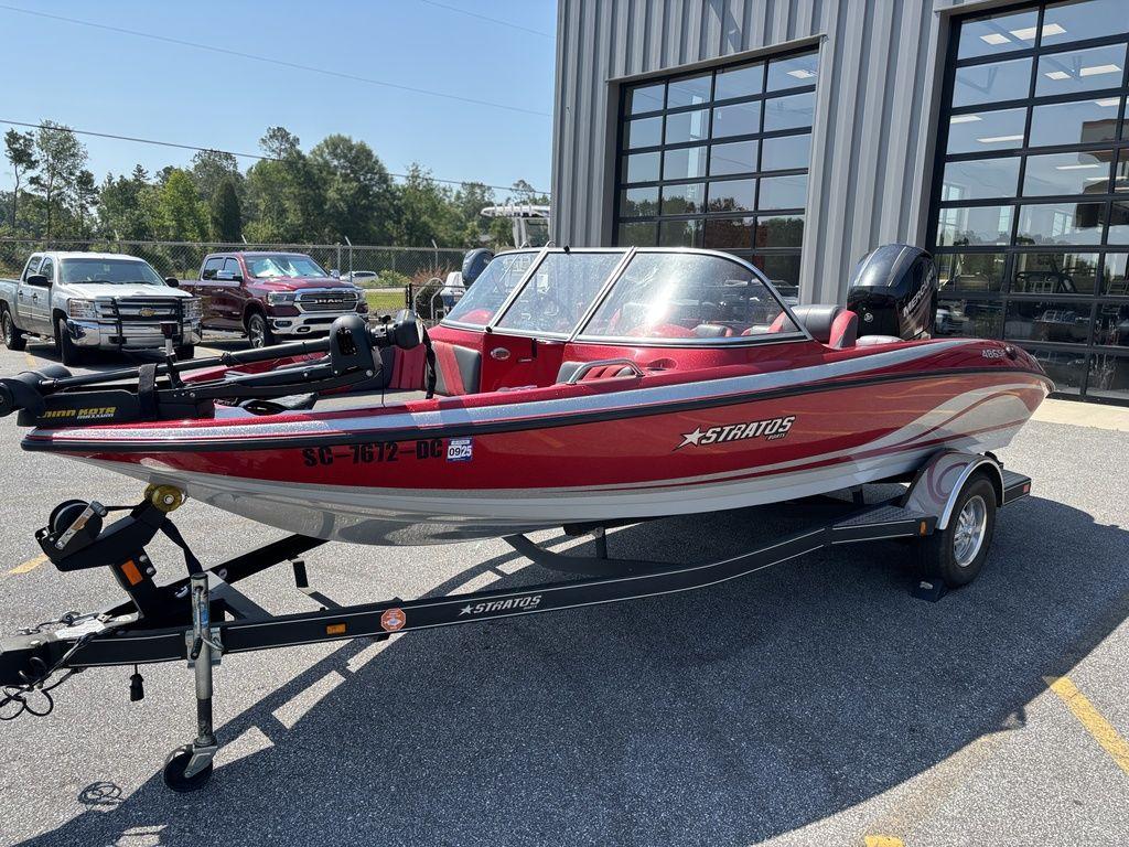 Red 2013 Stratos 486 SF boat on trailer, parked outside a building.