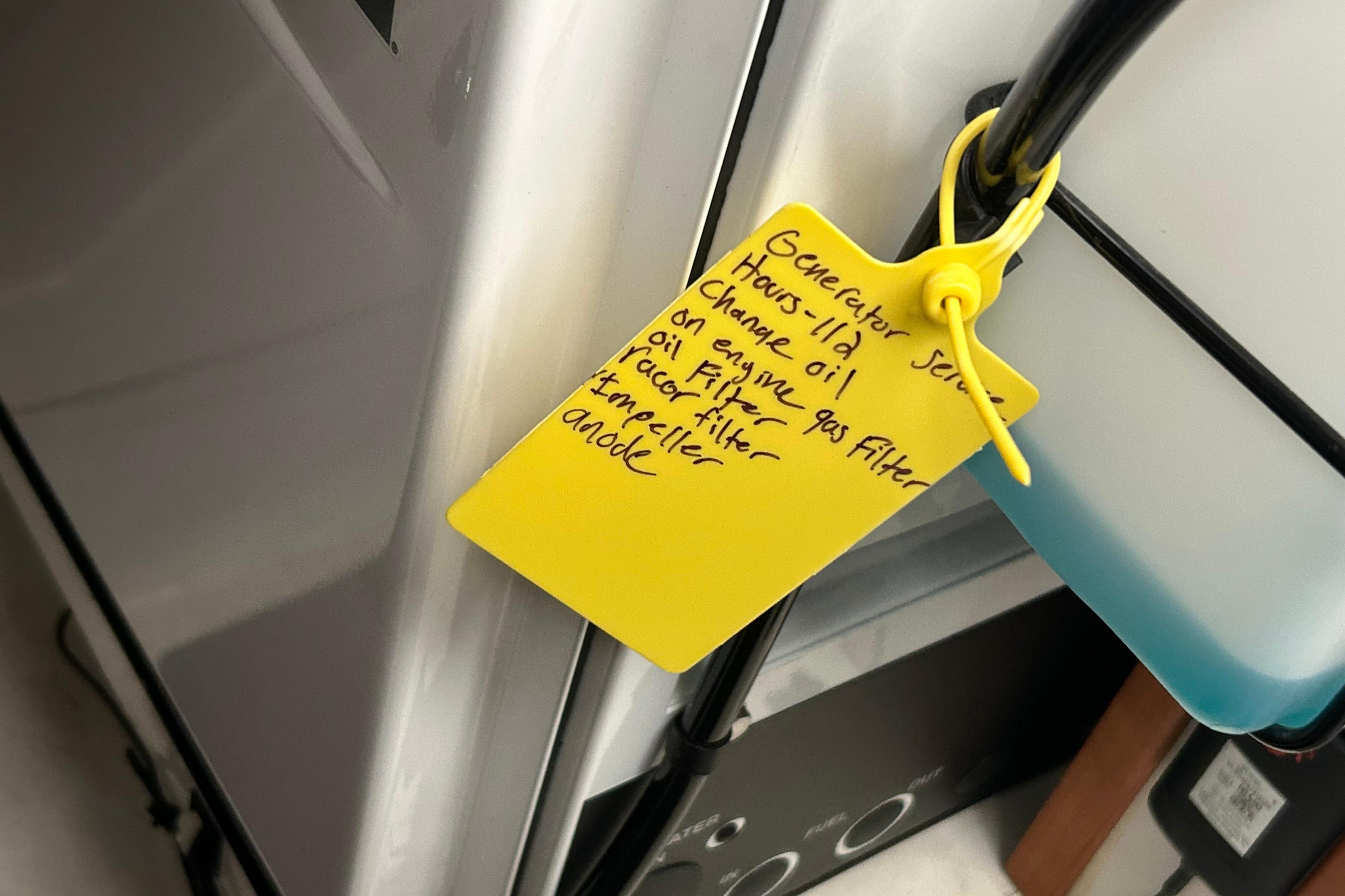 Yellow maintenance tag on Back Cove 39O, 2023 model, detailing generator service tasks.