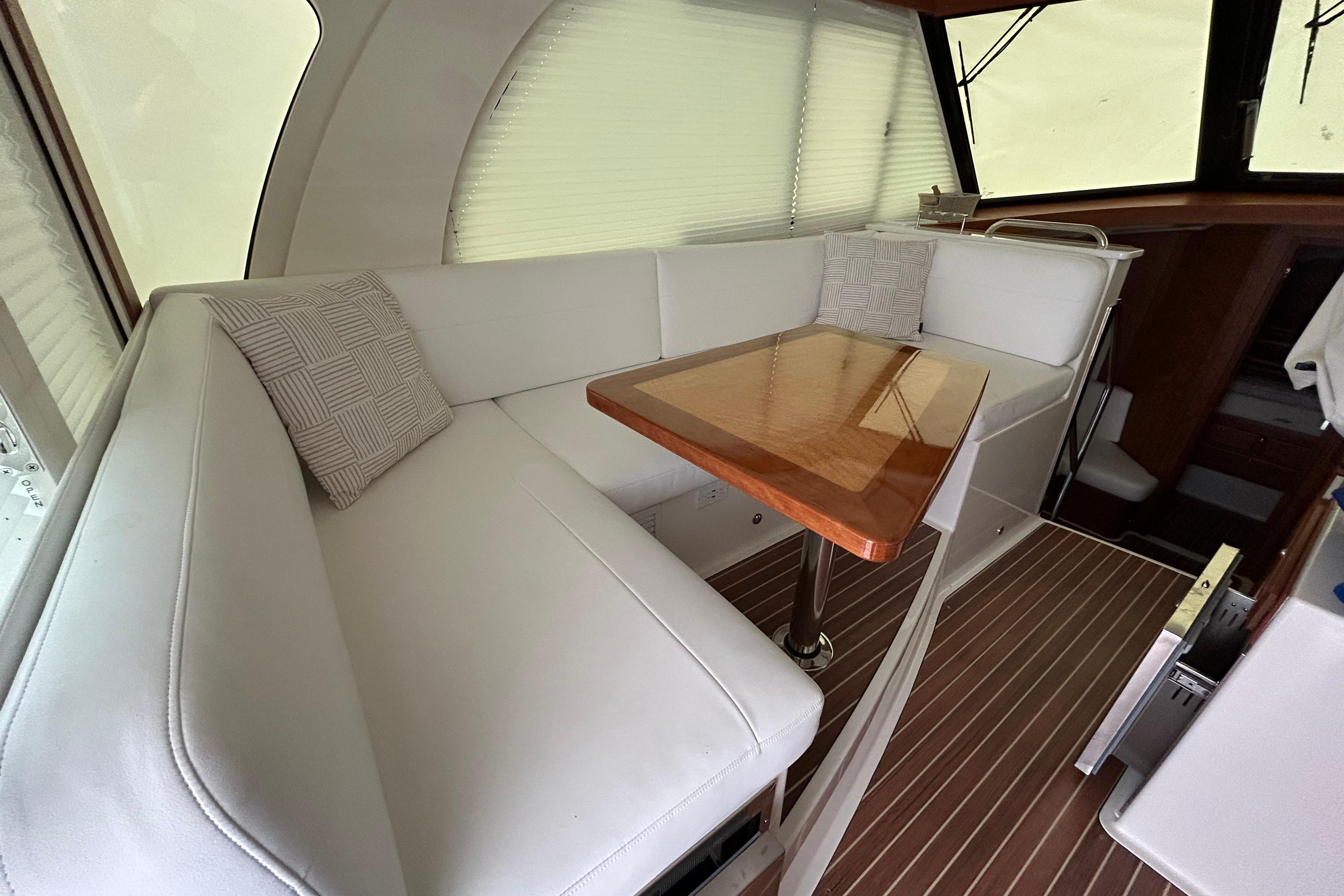 Luxurious interior of 2023 Back Cove 39O yacht with elegant seating and wooden table.