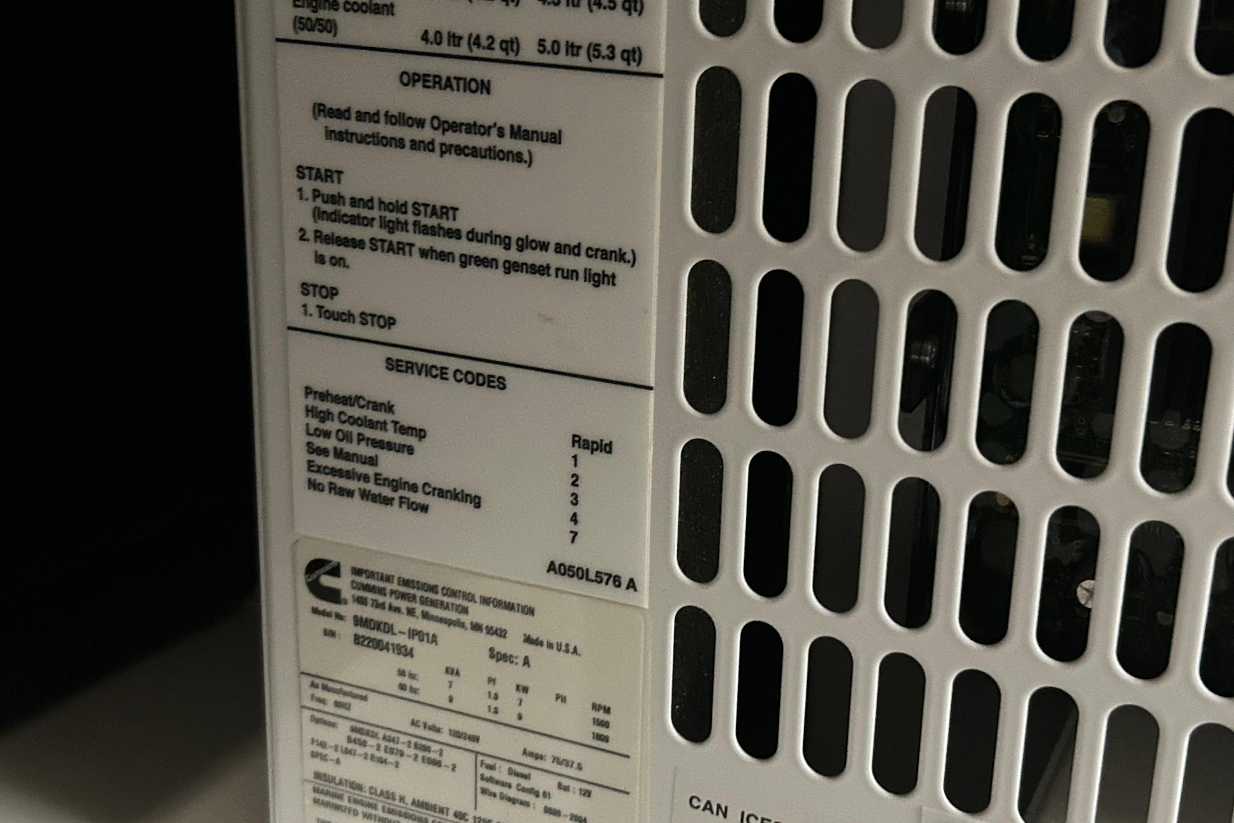 Close-up of a Cummins generator panel with operation instructions and service codes.