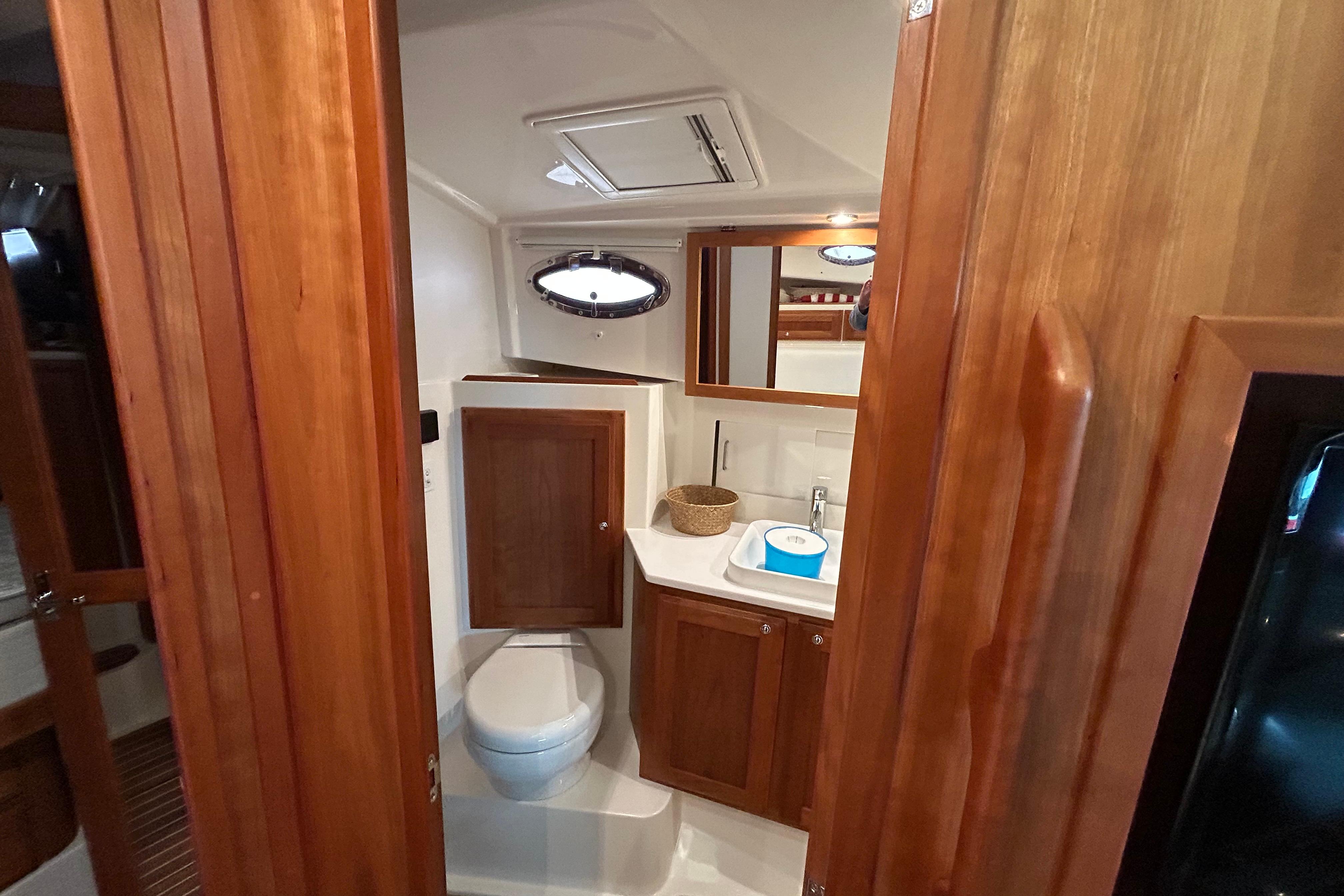 2023 Back Cove 39O yacht bathroom with wooden cabinetry and modern fixtures.