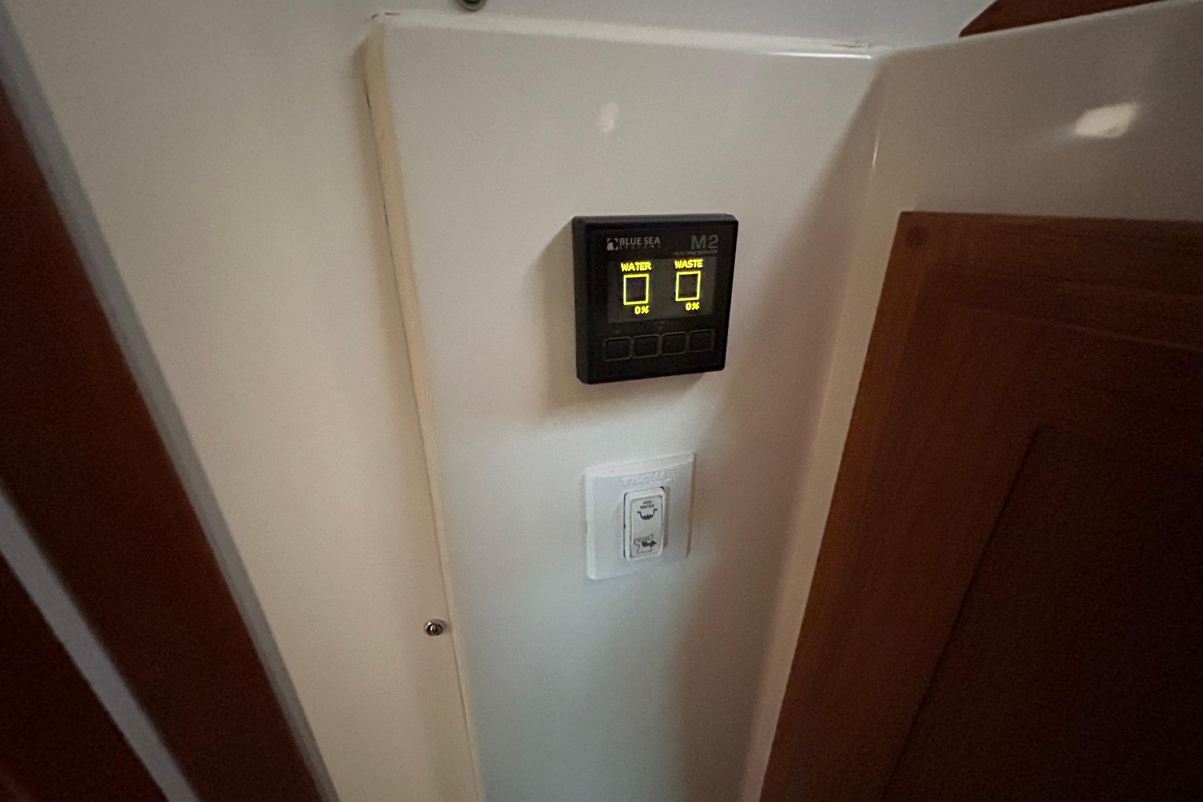 Control panel inside 2023 Back Cove 39O boat, displaying water and waste levels.