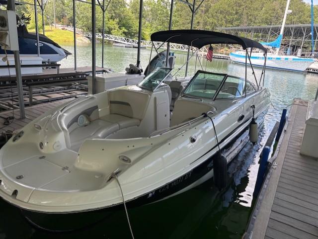 2007 Chaparral Sunesta 274 boat docked in a marina, featuring a sleek design and canopy.