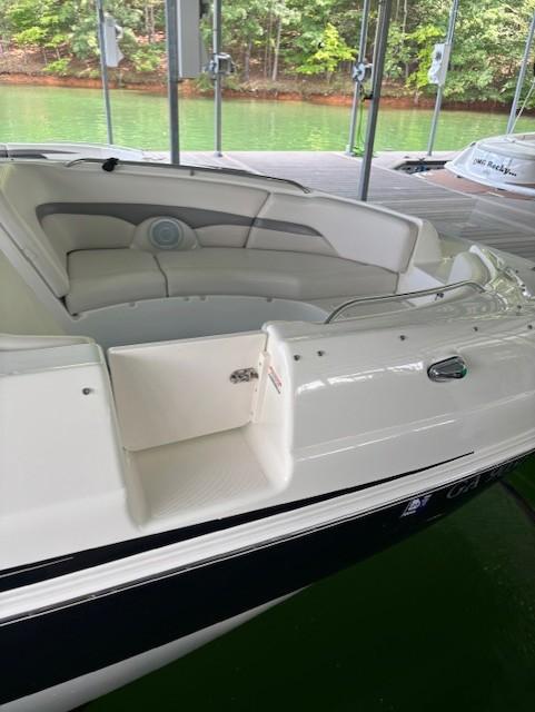 2007 Chaparral Sunesta 274 boat with white seating, docked near green water.