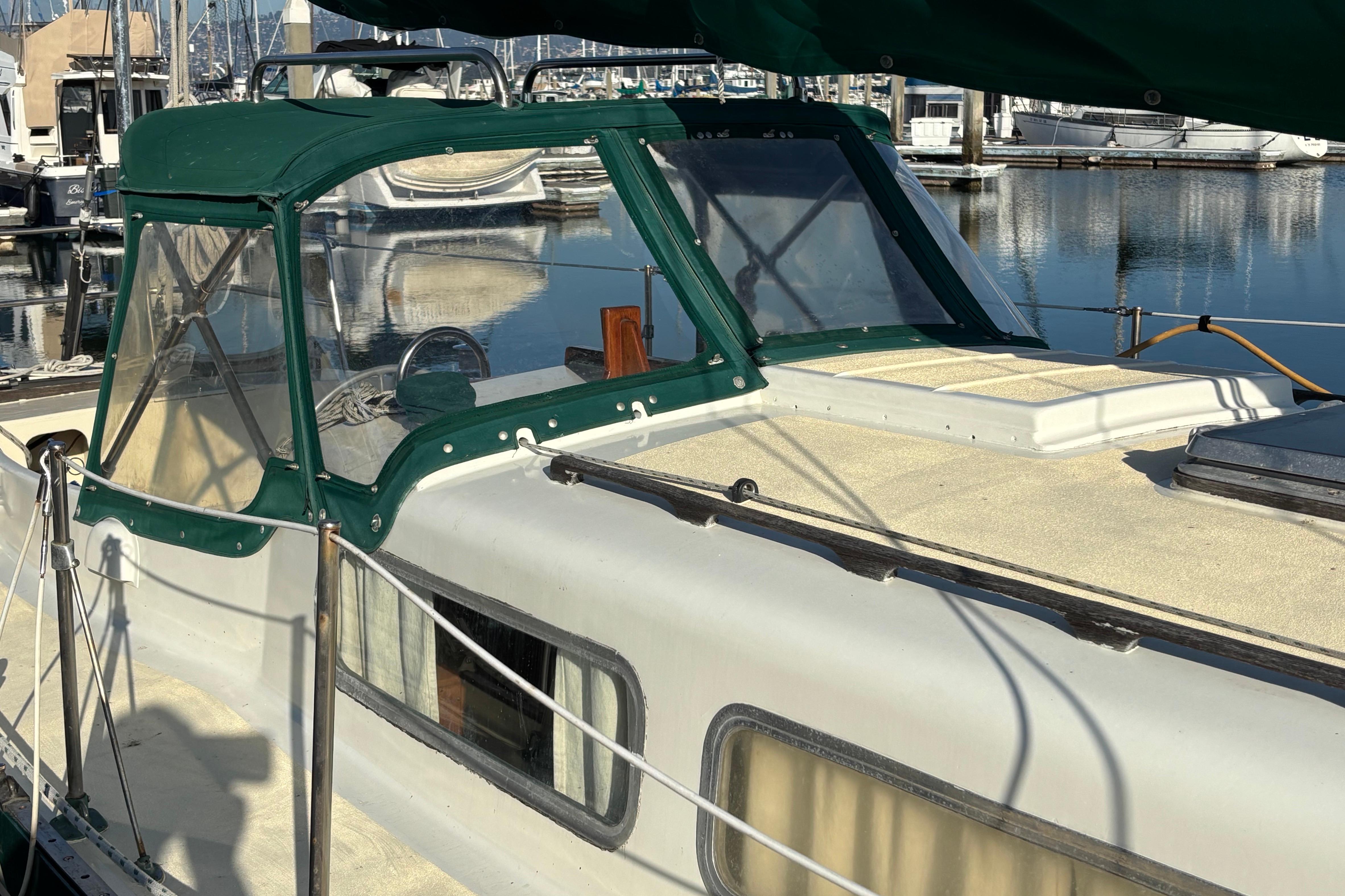 1968 Spencer 35 sailboat with green canopy docked in marina.
