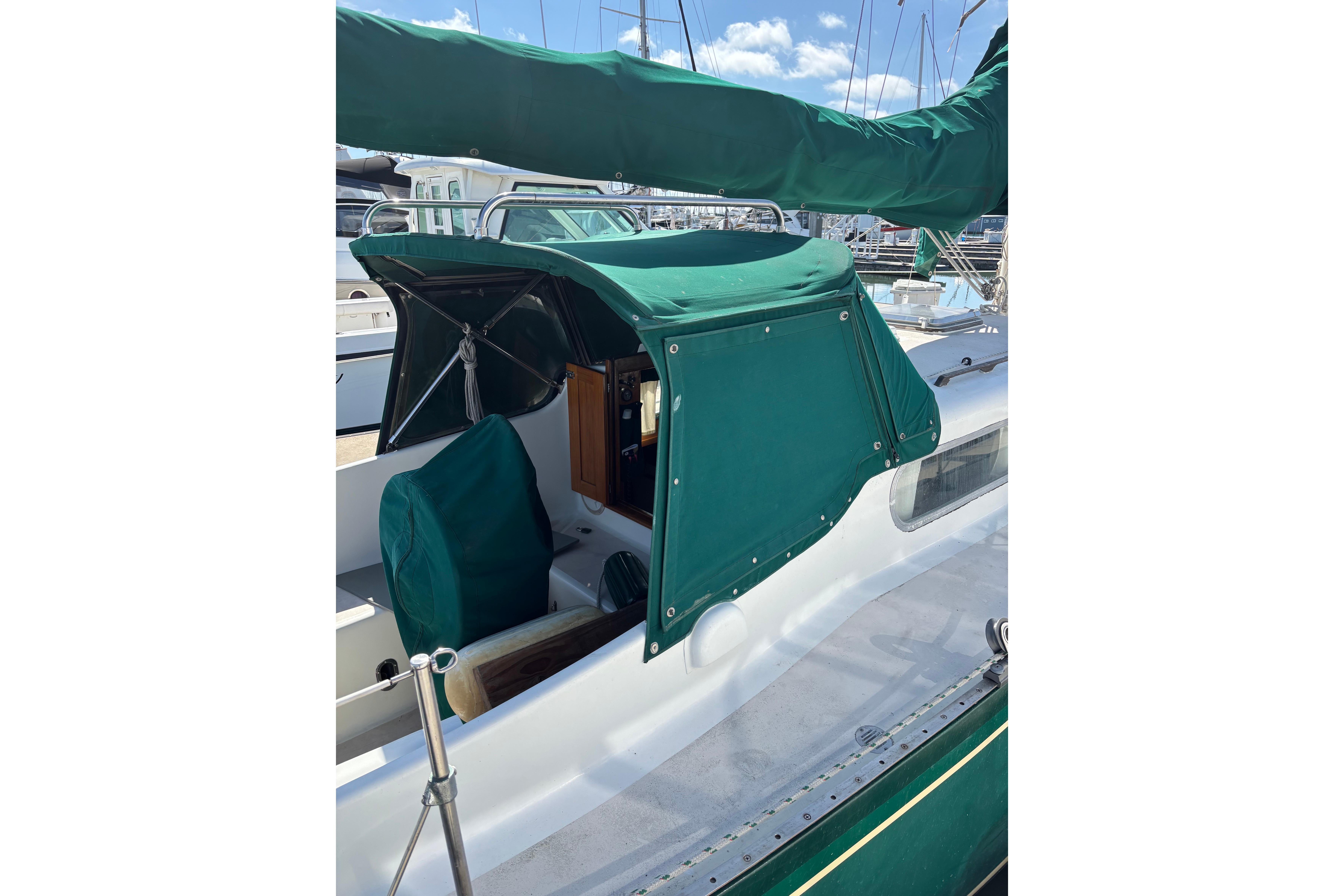 1968 Spencer 35 sailboat with green canvas cover in marina setting.