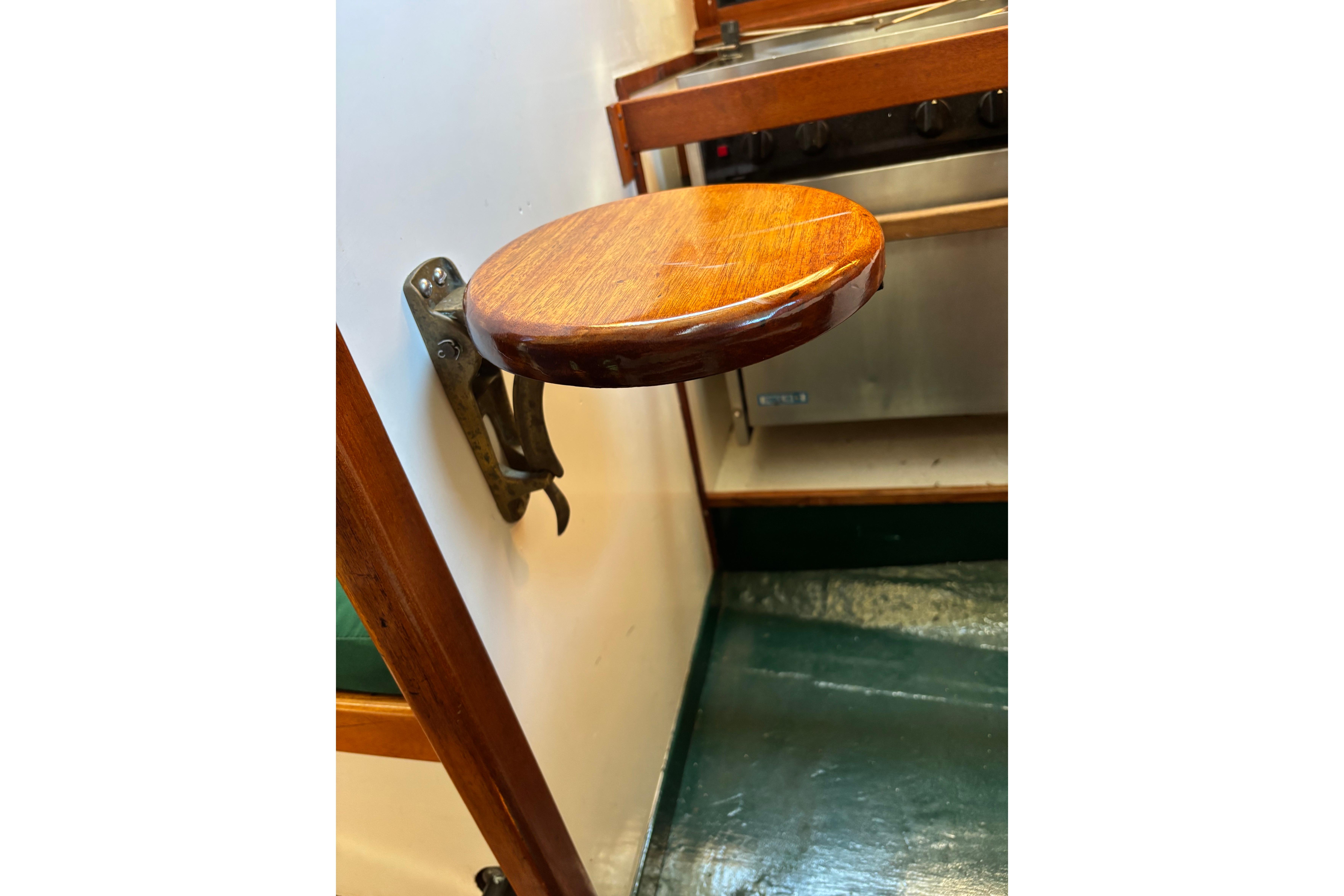 Wall-mounted wooden seat in a 1968 Spencer 35 boat interior.