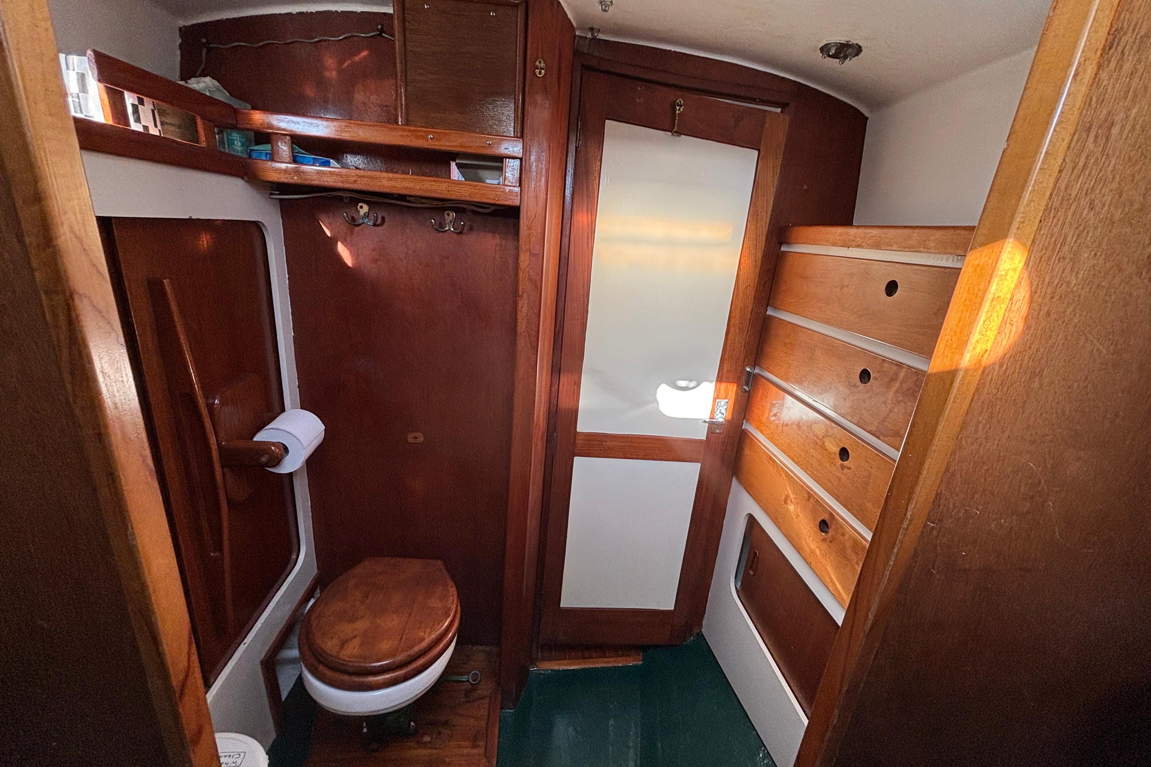 Vintage 1968 Spencer 35 yacht bathroom with wooden cabinetry and compact design.