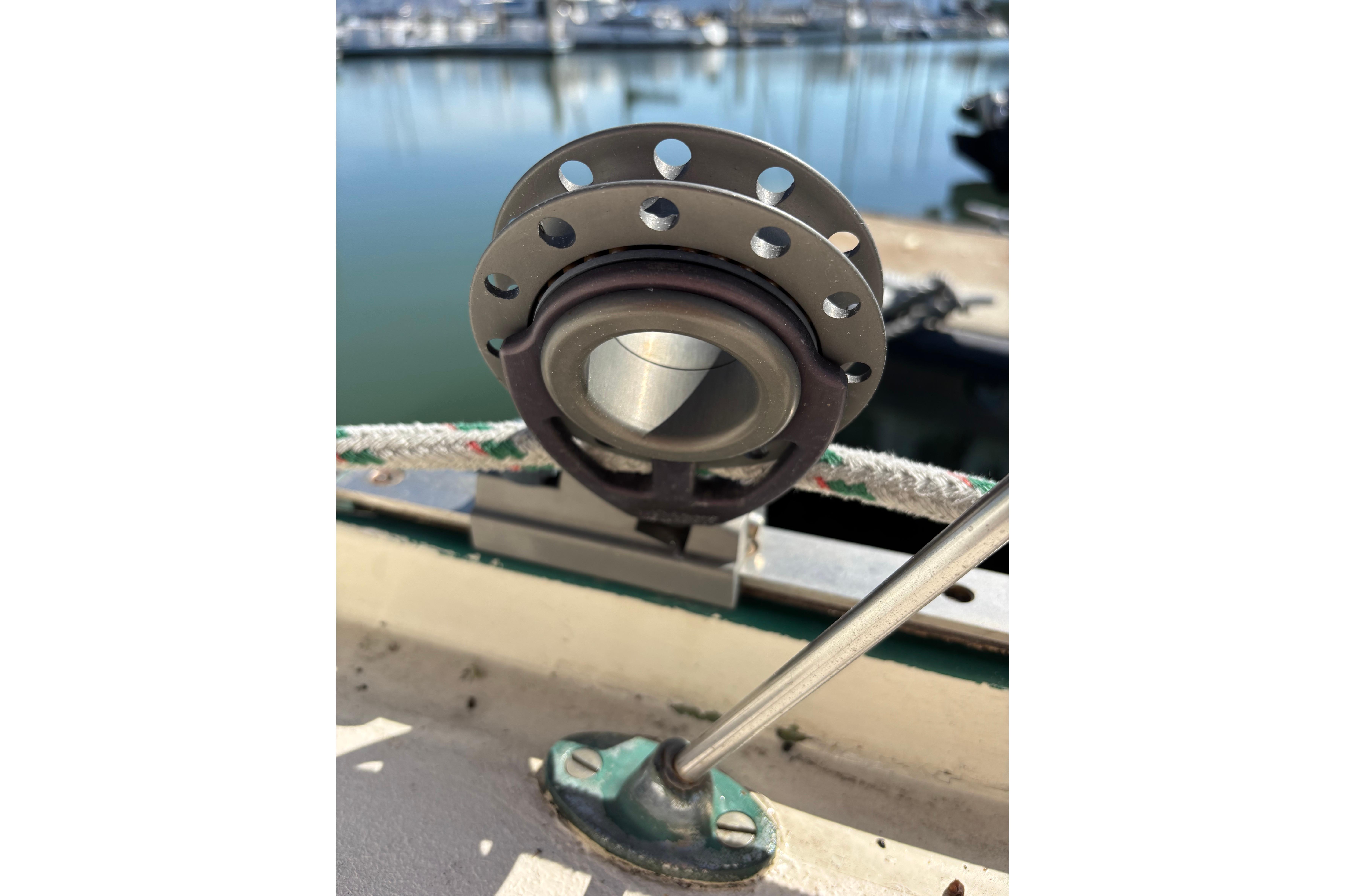 Close-up of a 1968 Spencer 35 sailboat fitting with marina background.