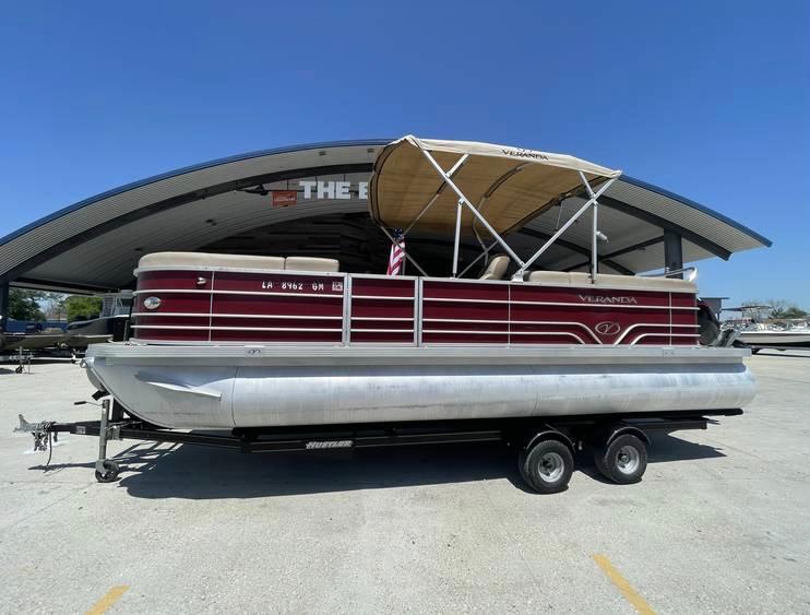 2018 Veranda 22 pontoon boat on trailer, parked outdoors under clear blue sky.