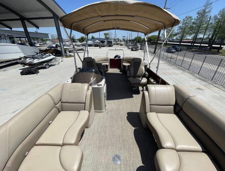 2018 Veranda 22 pontoon boat with beige seating and canopy, parked in a marina.