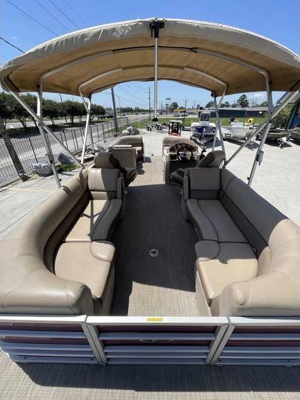 2018 Veranda 22 pontoon boat with beige seating and canopy, parked outdoors.