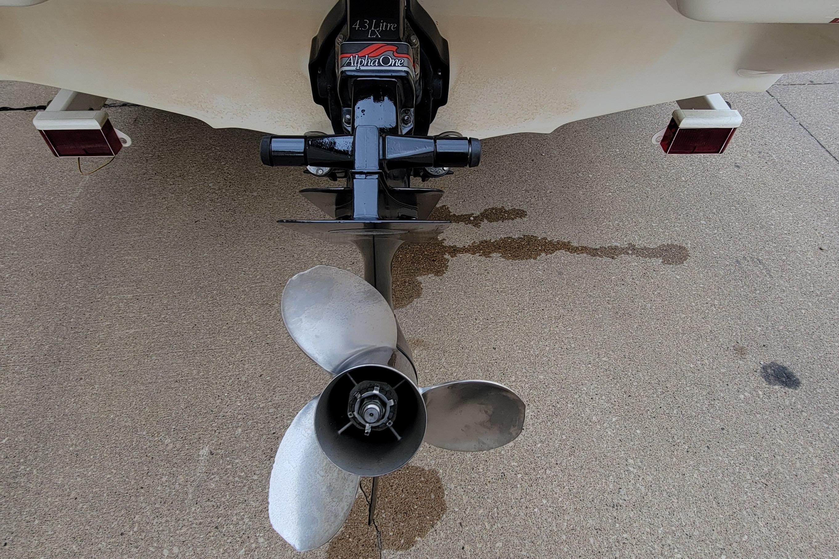 1994 Sea Ray 180 Bow Rider boat propeller and Alpha One outdrive on concrete surface.