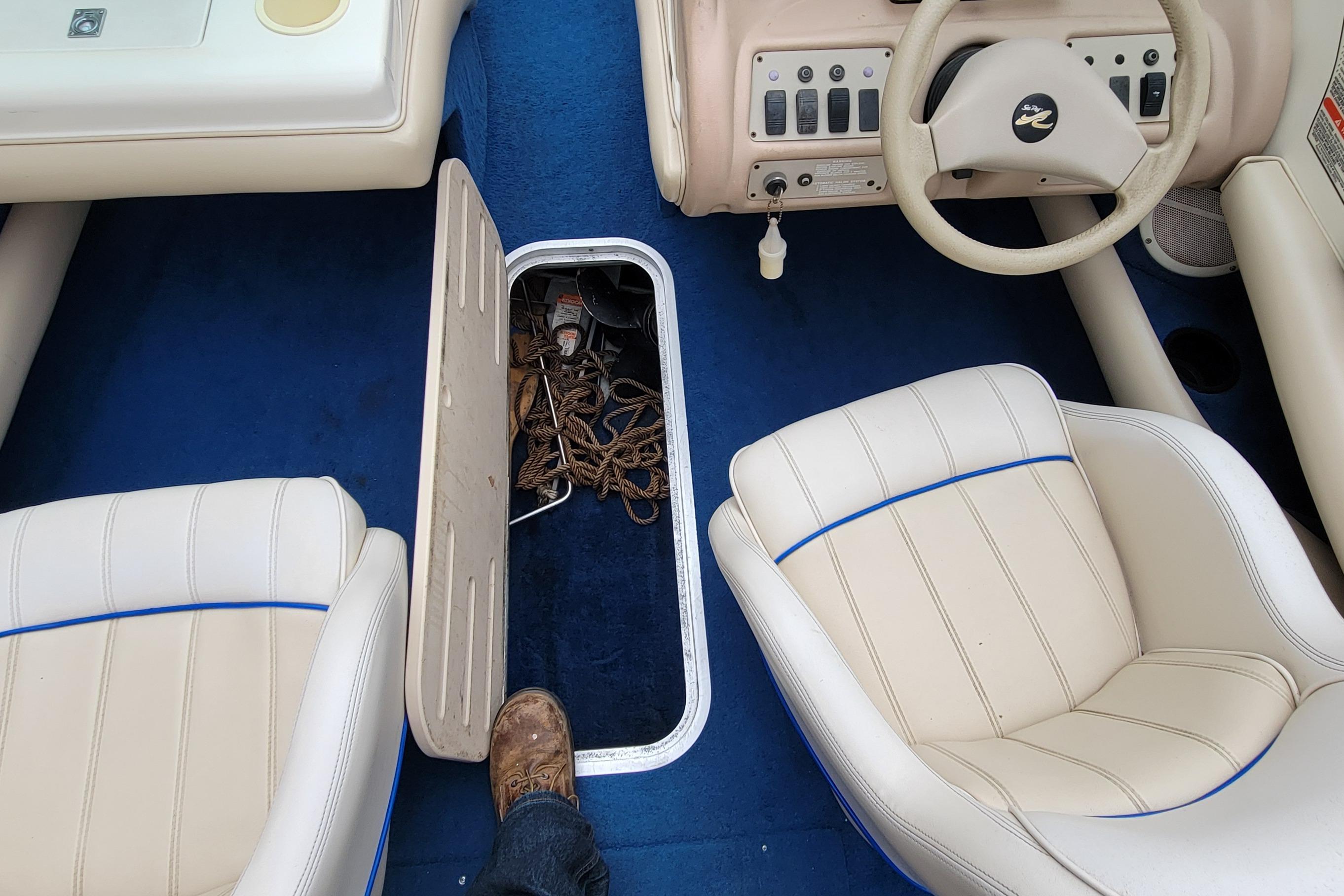 1994 Sea Ray 180 Bow Rider interior with blue carpet and beige seats.